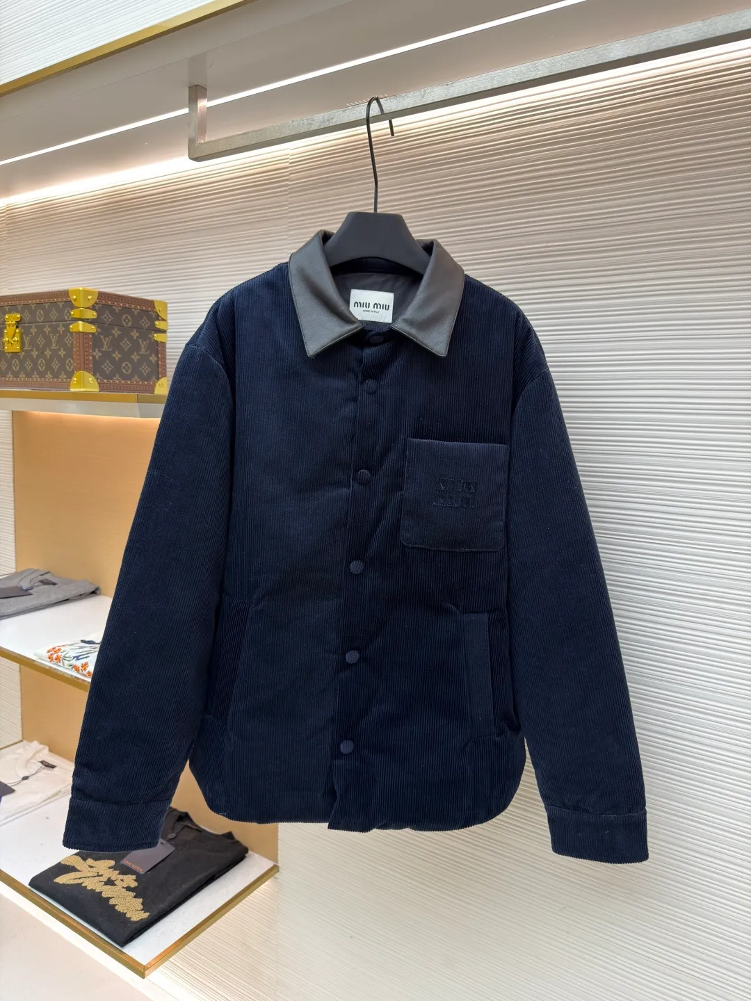 MIUMIU leather collar corduroy down jacket ●Original version: purchased and developed by 16097 ●Item number: 1681743-C75 ●Fabric: corduroy fabric ●Technology: patch embroidery production ●Color: navy blue ●Version: fitted version ●Weight: about 935 grams ●Size: 46-48-50-52 ●Description: When embroidery of the same color quietly grows among the corduroy textures - MIUMIU redefines winter elegance with "hidden beauty", making warmth a tacit whisper. Classic fine-ribbed corduroy wraps the body, with down like clouds lurking between the convex and convex warps and wefts. 90% white duck down silently resists the cold wind, but lets the fabric speak for itself - every velvet is the path of sunlight, and every ridge is a fortress built by warmth. The custom-made lambskin lapel falls along the curve of the neck, making it breathable like a second skin. Cold leather and soft suede complete a material game on the collar, and the sound of metal snaps opening and closing becomes the only punctuation mark in this dialogue. Exquisite appliqué technology performs visual magic on the left breast pocket: the embroidered letter patches are laser cut and shaped to create an embossed texture and clear fonts. Each patch undergoes 5 layers of anti-wrinkle treatment to ensure that it retains its original shape after washing. The embroidered fabric of the same color as the fabric runs along the MIUMIU logo, with only subtle gloss differences and raised stitches to enhance visual recognition. The overall wiring is straight and delicate, the fabric is comfortable and soft, and the color is consistent without color difference. It can be matched with the same style to create a fashionable look and control various occasions. Customized accessories, complete with three standards, same style for men and women!