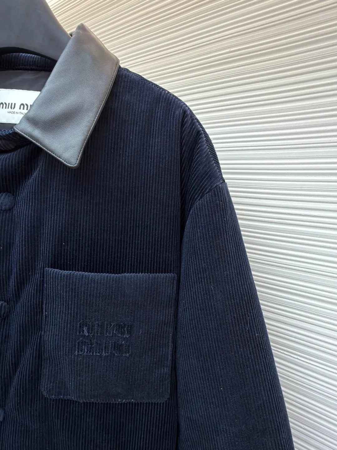 MIUMIU leather collar corduroy down jacket ●Original version: purchased and developed by 16097 ●Item number: 1681743-C75 ●Fabric: corduroy fabric ●Technology: patch embroidery production ●Color: navy blue ●Version: fitted version ●Weight: about 935 grams ●Size: 46-48-50-52 ●Description: When embroidery of the same color quietly grows among the corduroy textures - MIUMIU redefines winter elegance with "hidden beauty", making warmth a tacit whisper. Classic fine-ribbed corduroy wraps the body, with down like clouds lurking between the convex and convex warps and wefts. 90% white duck down silently resists the cold wind, but lets the fabric speak for itself - every velvet is the path of sunlight, and every ridge is a fortress built by warmth. The custom-made lambskin lapel falls along the curve of the neck, making it breathable like a second skin. Cold leather and soft suede complete a material game on the collar, and the sound of metal snaps opening and closing becomes the only punctuation mark in this dialogue. Exquisite appliqué technology performs visual magic on the left breast pocket: the embroidered letter patches are laser cut and shaped to create an embossed texture and clear fonts. Each patch undergoes 5 layers of anti-wrinkle treatment to ensure that it retains its original shape after washing. The embroidered fabric of the same color as the fabric runs along the MIUMIU logo, with only subtle gloss differences and raised stitches to enhance visual recognition. The overall wiring is straight and delicate, the fabric is comfortable and soft, and the color is consistent without color difference. It can be matched with the same style to create a fashionable look and control various occasions. Customized accessories, complete with three standards, same style for men and women!