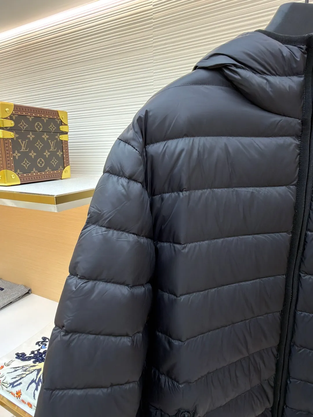 MIU MIU hooded down jacket ●Item number: 1681314-C55 ●Material: white duck down fabric ●Technology: mechanical down filling ●Color: black ●Version: fitted version ●Weight: about 615 grams ●Size: S-M-L-XL ●Description: This is a light down jacket from the MiuMiu brand. Its craftsmanship details are as follows: It is made of exquisite pongé fabric made of 100% recycled polyester fiber. This fabric has good windproof performance, and at the same time has a delicate texture and a high-end luster. It has high fluffiness, excellent warmth retention and is very light overall, allowing the wearer to gain warmth without any heavy burden. It has a three-dimensional cut and a neat silhouette. Precision stitching technology is used during sewing to form regular quilting lines, which not only serves to fix the down, but also enhances the structure and design of the garment. The stitches are fine and even, and the seams are smooth, reflecting the exquisite craftsmanship of garment making. Equipped with a customized wax zipper, the zipper is smooth and durable, and the zipper puller has brand details and a high-quality feel. The hooded design fits the head and increases warmth; the drawstring cuffs can be adjusted according to needs to prevent cold wind from entering; the elastic drawstring at the hem can adjust the looseness of the hem, improving the comfort and practicality of wearing; there is the brand's embroidered logo on the chest, with fine craftsmanship and highlighting the brand identity.