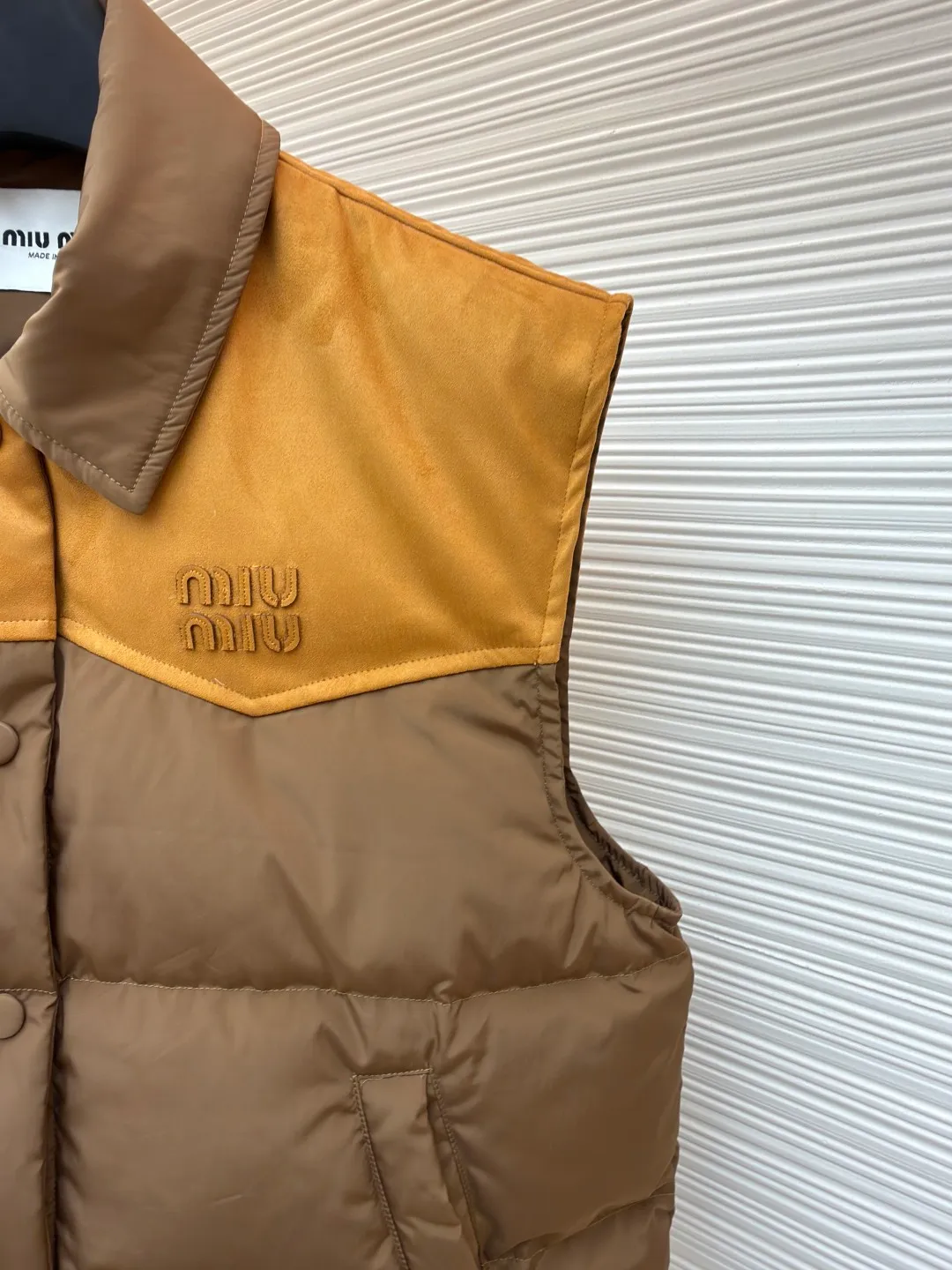 MIUMIU flocked stitching lapel vest ●Original version: purchased and developed by 26615 ●Item number: 1681923-B50 ●Fabric: white duck down fabric ●Technology: embossed flocking production ●Color: brown ●Version: fitted version ●Weight: about 495 grams ●Size: S-M-L ●Description: This style is Miu Miu-style patchwork vest uses collision splicing technology: the main body is made of high-density matte nylon fabric, which is wind-resistant and anti-sand velvet; the collar and chest area are spliced with fine suede, and the texture contrast is enhanced by diagonal stitching. The filling is made of high-fill white duck down, and the segmented down filling process ensures an even amount of down in each grid, with a fill power of 600+; the placket is designed with metal snaps and a built-in concealed buckle for double temperature locking. The "MIU MIU" logo on the front chest adopts embossed flocking technology, which has a three-dimensional touch and is not easy to fall off; the cuffs and hem are elasticized to fit the body shape. The overall stitching uses anti-drilling velvet hemming needles, and the pockets are obliquely inserted invisible pockets, taking into account both beauty and practicality. It is a fashionable style that is lightweight and warm in autumn and winter. The overall wiring is straight and delicate, the fabric is comfortable and soft, and the color is consistent without color difference. It can be matched with the same style to create a fashionable look and control various occasions. Customized accessories, complete with three standards, same style for men and women!