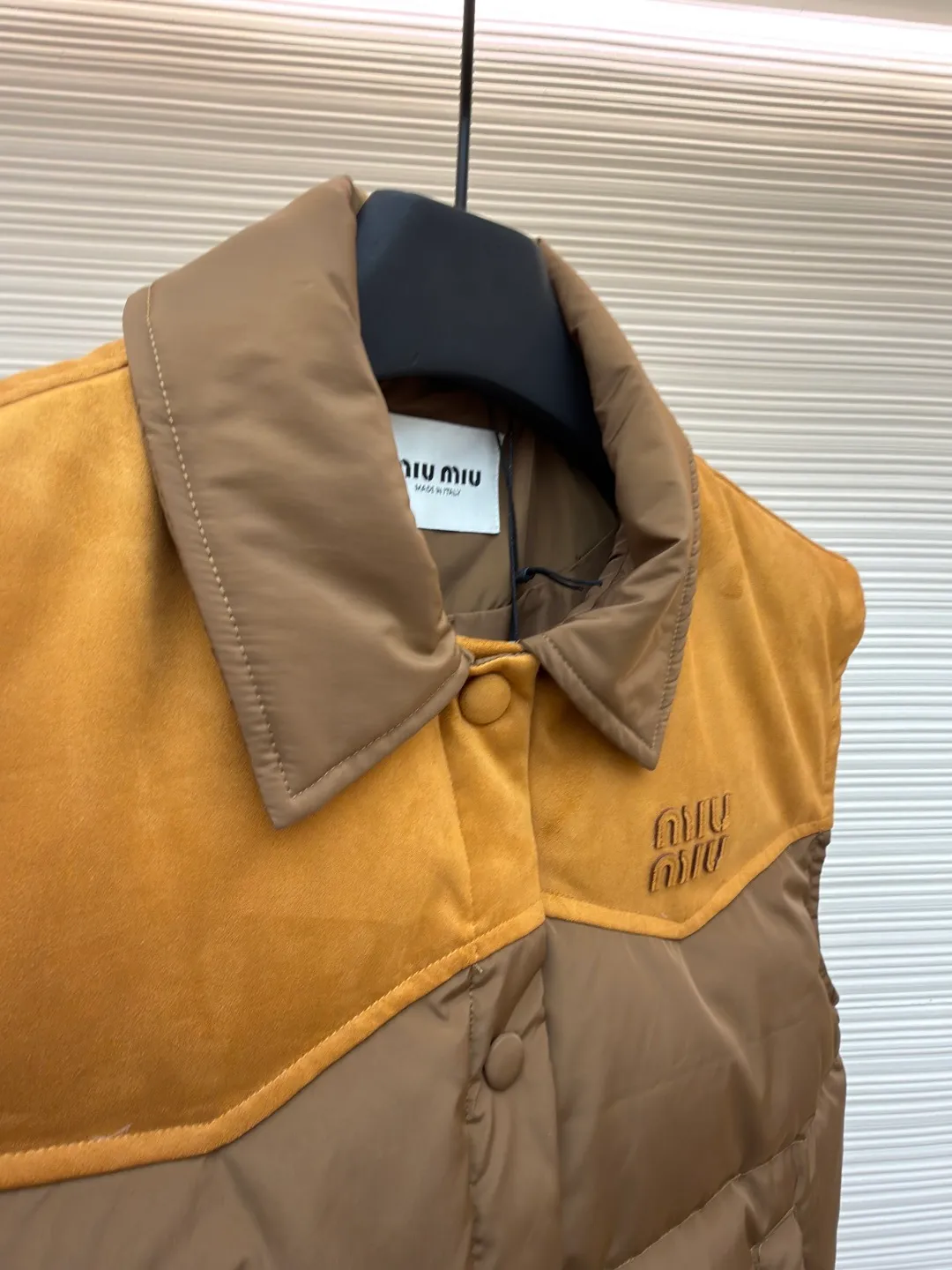 MIUMIU flocked stitching lapel vest ●Original version: purchased and developed by 26615 ●Item number: 1681923-B50 ●Fabric: white duck down fabric ●Technology: embossed flocking production ●Color: brown ●Version: fitted version ●Weight: about 495 grams ●Size: S-M-L ●Description: This style is Miu Miu-style patchwork vest uses collision splicing technology: the main body is made of high-density matte nylon fabric, which is wind-resistant and anti-sand velvet; the collar and chest area are spliced with fine suede, and the texture contrast is enhanced by diagonal stitching. The filling is made of high-fill white duck down, and the segmented down filling process ensures an even amount of down in each grid, with a fill power of 600+; the placket is designed with metal snaps and a built-in concealed buckle for double temperature locking. The "MIU MIU" logo on the front chest adopts embossed flocking technology, which has a three-dimensional touch and is not easy to fall off; the cuffs and hem are elasticized to fit the body shape. The overall stitching uses anti-drilling velvet hemming needles, and the pockets are obliquely inserted invisible pockets, taking into account both beauty and practicality. It is a fashionable style that is lightweight and warm in autumn and winter. The overall wiring is straight and delicate, the fabric is comfortable and soft, and the color is consistent without color difference. It can be matched with the same style to create a fashionable look and control various occasions. Customized accessories, complete with three standards, same style for men and women!