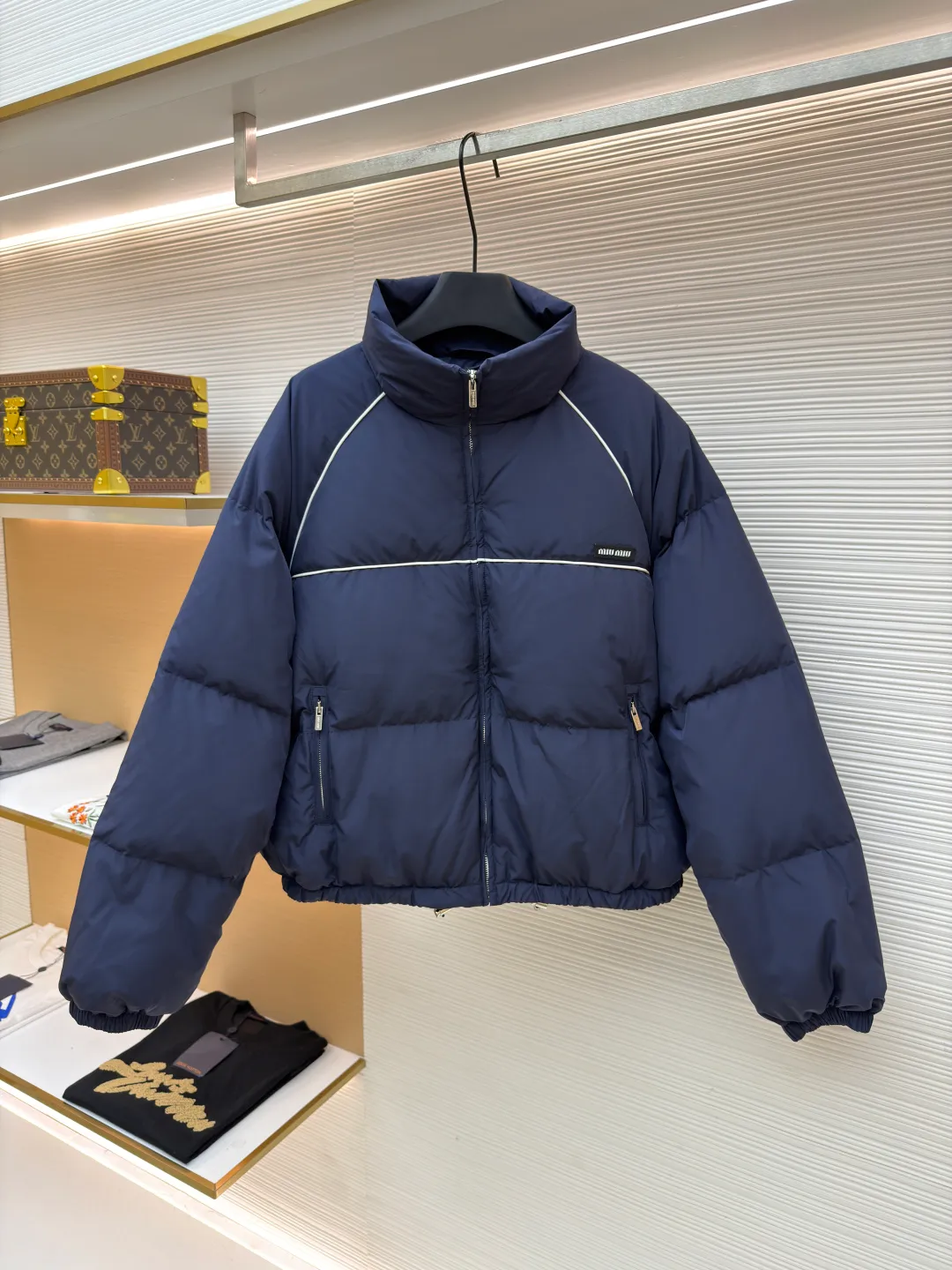 MIUMIU logo down jacket ●Original version: purchased and developed at 18695 ●Item number: 1861323-C95 ●Fabric: white duck down fabric ●Technology: mechanical down filling ●Color: navy ●Type: fitted version ●Weight: about 810 grams ●Size: 46-48-50-52 ●Description: Different from ordinary fabrics, custom-developed high-count and high-density woven fabrics. Imported computerized down filling equipment is used to ensure that the amount of down filling in each independent quilting grid is accurate and even, avoiding local holes or agglomerations, thereby ensuring the overall flatness, uniformity of warmth and long-lasting fluffiness of the down jacket. From the treatment of the interior, the firmness of the stitching of the zippers, to the precise positioning of decorative elements such as logos, the factory's craftsmanship ensures that the entire piece has impeccable finish and durable quality, making it a long-term wardrobe treasure worth owning. The overall wiring is straight and delicate, the fabric is comfortable and soft, and the color is consistent without color difference. It can be matched with the same style to create a fashionable look and control various occasions. Customized accessories, complete with three standards, same style for men and women!