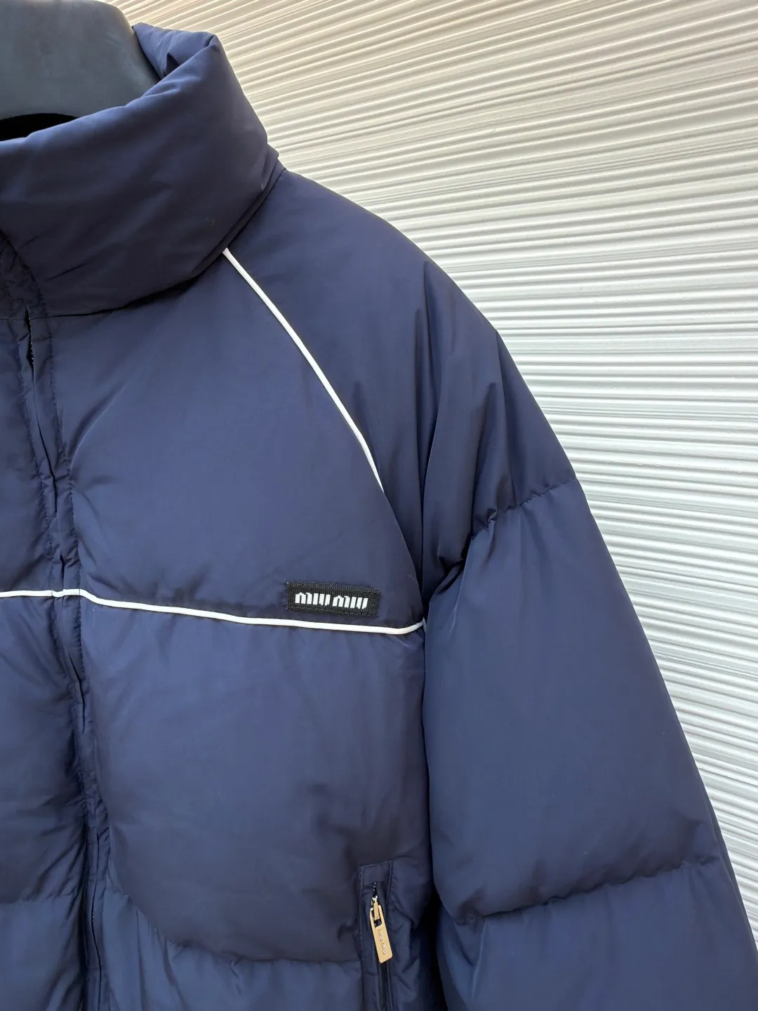 MIUMIU logo down jacket ●Original version: purchased and developed at 18695 ●Item number: 1861323-C95 ●Fabric: white duck down fabric ●Technology: mechanical down filling ●Color: navy ●Type: fitted version ●Weight: about 810 grams ●Size: 46-48-50-52 ●Description: Different from ordinary fabrics, custom-developed high-count and high-density woven fabrics. Imported computerized down filling equipment is used to ensure that the amount of down filling in each independent quilting grid is accurate and even, avoiding local holes or agglomerations, thereby ensuring the overall flatness, uniformity of warmth and long-lasting fluffiness of the down jacket. From the treatment of the interior, the firmness of the stitching of the zippers, to the precise positioning of decorative elements such as logos, the factory's craftsmanship ensures that the entire piece has impeccable finish and durable quality, making it a long-term wardrobe treasure worth owning. The overall wiring is straight and delicate, the fabric is comfortable and soft, and the color is consistent without color difference. It can be matched with the same style to create a fashionable look and control various occasions. Customized accessories, complete with three standards, same style for men and women!