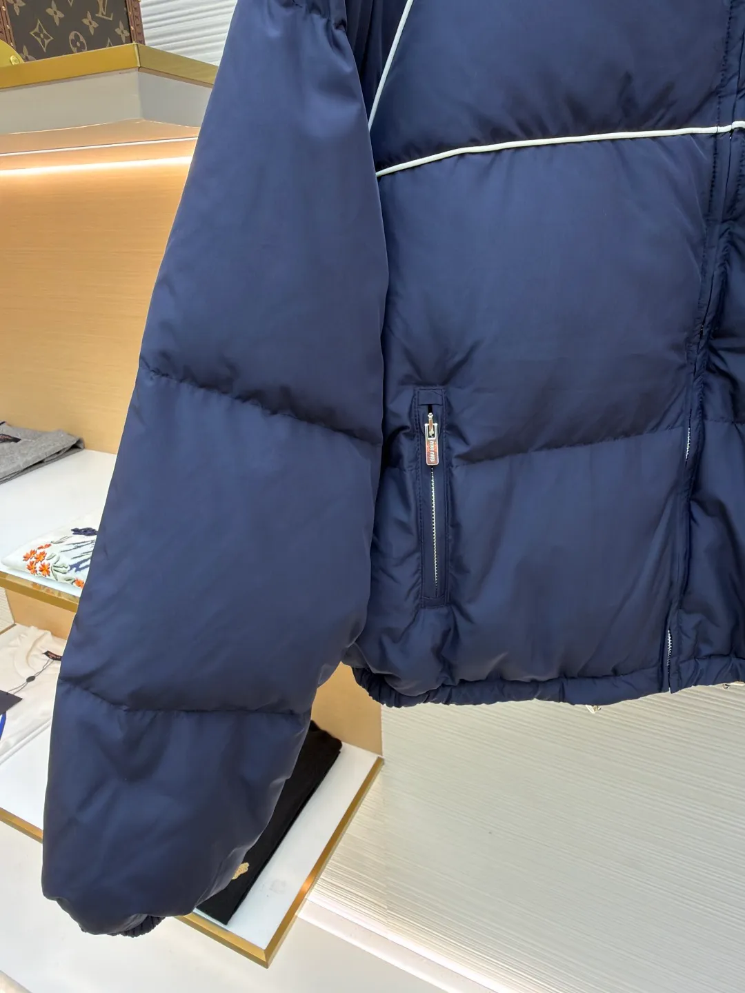 MIUMIU logo down jacket ●Original version: purchased and developed at 18695 ●Item number: 1861323-C95 ●Fabric: white duck down fabric ●Technology: mechanical down filling ●Color: navy ●Type: fitted version ●Weight: about 810 grams ●Size: 46-48-50-52 ●Description: Different from ordinary fabrics, custom-developed high-count and high-density woven fabrics. Imported computerized down filling equipment is used to ensure that the amount of down filling in each independent quilting grid is accurate and even, avoiding local holes or agglomerations, thereby ensuring the overall flatness, uniformity of warmth and long-lasting fluffiness of the down jacket. From the treatment of the interior, the firmness of the stitching of the zippers, to the precise positioning of decorative elements such as logos, the factory's craftsmanship ensures that the entire piece has impeccable finish and durable quality, making it a long-term wardrobe treasure worth owning. The overall wiring is straight and delicate, the fabric is comfortable and soft, and the color is consistent without color difference. It can be matched with the same style to create a fashionable look and control various occasions. Customized accessories, complete with three standards, same style for men and women!