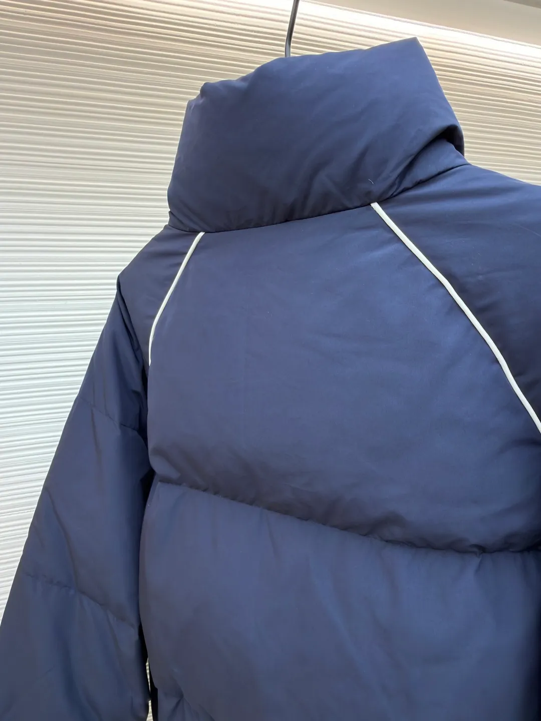 MIUMIU logo down jacket ●Original version: purchased and developed at 18695 ●Item number: 1861323-C95 ●Fabric: white duck down fabric ●Technology: mechanical down filling ●Color: navy ●Type: fitted version ●Weight: about 810 grams ●Size: 46-48-50-52 ●Description: Different from ordinary fabrics, custom-developed high-count and high-density woven fabrics. Imported computerized down filling equipment is used to ensure that the amount of down filling in each independent quilting grid is accurate and even, avoiding local holes or agglomerations, thereby ensuring the overall flatness, uniformity of warmth and long-lasting fluffiness of the down jacket. From the treatment of the interior, the firmness of the stitching of the zippers, to the precise positioning of decorative elements such as logos, the factory's craftsmanship ensures that the entire piece has impeccable finish and durable quality, making it a long-term wardrobe treasure worth owning. The overall wiring is straight and delicate, the fabric is comfortable and soft, and the color is consistent without color difference. It can be matched with the same style to create a fashionable look and control various occasions. Customized accessories, complete with three standards, same style for men and women!