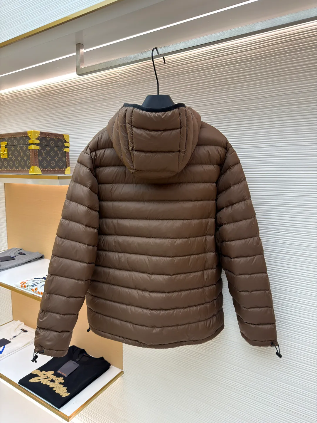 MIU MIU hooded down jacket ●Item number: 1681315-C55 ●Material: white duck down fabric ●Technology: mechanical down filling ●Color: brown ●Version: fitted version ●Weight: about 615 grams ●Size: S-M-L-XL ●Description: This is a light down jacket from the MiuMiu brand. Its craftsmanship details are as follows: It is made of exquisite pongé fabric made of 100% recycled polyester fiber. This fabric has good windproof performance, and at the same time has a delicate texture and a high-end luster. It has high fluffiness, excellent warmth retention and is very light overall, allowing the wearer to gain warmth without any heavy burden. It has a three-dimensional cut and a neat silhouette. Precision stitching technology is used during sewing to form regular quilting lines, which not only serves to fix the down, but also enhances the structure and design of the garment. The stitches are fine and even, and the seams are smooth, reflecting the exquisite craftsmanship of garment making. Equipped with a customized wax zipper, the zipper is smooth and durable, and the zipper puller has brand details and a high-quality feel. The hooded design fits the head and increases warmth; the drawstring cuffs can be adjusted according to needs to prevent cold wind from entering; the elastic drawstring at the hem can adjust the looseness of the hem, improving the comfort and practicality of wearing; there is the brand's embroidered logo on the chest, with fine craftsmanship and highlighting the brand identity.
