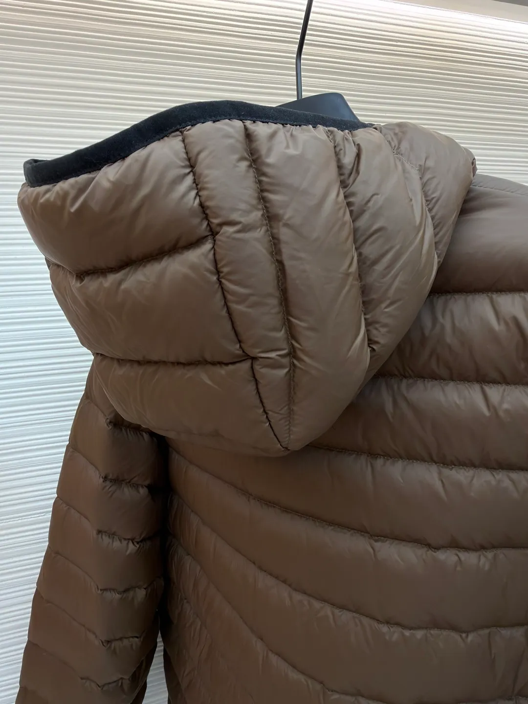 MIU MIU hooded down jacket ●Item number: 1681315-C55 ●Material: white duck down fabric ●Technology: mechanical down filling ●Color: brown ●Version: fitted version ●Weight: about 615 grams ●Size: S-M-L-XL ●Description: This is a light down jacket from the MiuMiu brand. Its craftsmanship details are as follows: It is made of exquisite pongé fabric made of 100% recycled polyester fiber. This fabric has good windproof performance, and at the same time has a delicate texture and a high-end luster. It has high fluffiness, excellent warmth retention and is very light overall, allowing the wearer to gain warmth without any heavy burden. It has a three-dimensional cut and a neat silhouette. Precision stitching technology is used during sewing to form regular quilting lines, which not only serves to fix the down, but also enhances the structure and design of the garment. The stitches are fine and even, and the seams are smooth, reflecting the exquisite craftsmanship of garment making. Equipped with a customized wax zipper, the zipper is smooth and durable, and the zipper puller has brand details and a high-quality feel. The hooded design fits the head and increases warmth; the drawstring cuffs can be adjusted according to needs to prevent cold wind from entering; the elastic drawstring at the hem can adjust the looseness of the hem, improving the comfort and practicality of wearing; there is the brand's embroidered logo on the chest, with fine craftsmanship and highlighting the brand identity.