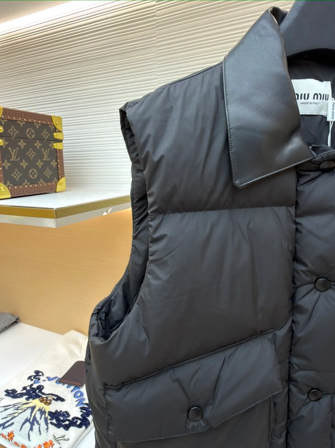 MIUMIU technology ponge down vest ●Item number: 1681319-C65 ●Material: white duck down fabric ●Technology: mechanical down filling ●Color: black ●Version: fitted version ●Weight: about 450 grams ●Size: S-M-L ●Description: This vest is made of lightweight and durable nylon fabric with down filling, taking into account warmth and fashion. The collar is made of genuine leather to improve the overall texture and warmth. The outer layer of high-density nylon is windproof and waterproof, lightweight and wear-resistant. The inner layer is filled with down, which has high fluffiness and warmth retention. It is made of national standard 90 white duck down and has a filling capacity of 190 grams to ensure excellent warmth retention. The down has been strictly screened and processed and is not easy to be drilled, ensuring durability. The letter pattern is displayed on the breast bag piece through glue printing. The printer scrapes the print 10 times to ensure the printing thickness, forming a micro-three-dimensional convex structure. The scraper pressure is even and the firmness is improved. After being cured at high temperature, the pigment is combined with the fabric fibers and is not easy to fall off due to friction. The overall wiring is straight and delicate, the fabric is comfortable and soft, and the color is consistent without color difference. It can be matched with the same style to create a fashionable look and control various occasions. Customized accessories, complete with three standards, same style for men and women!