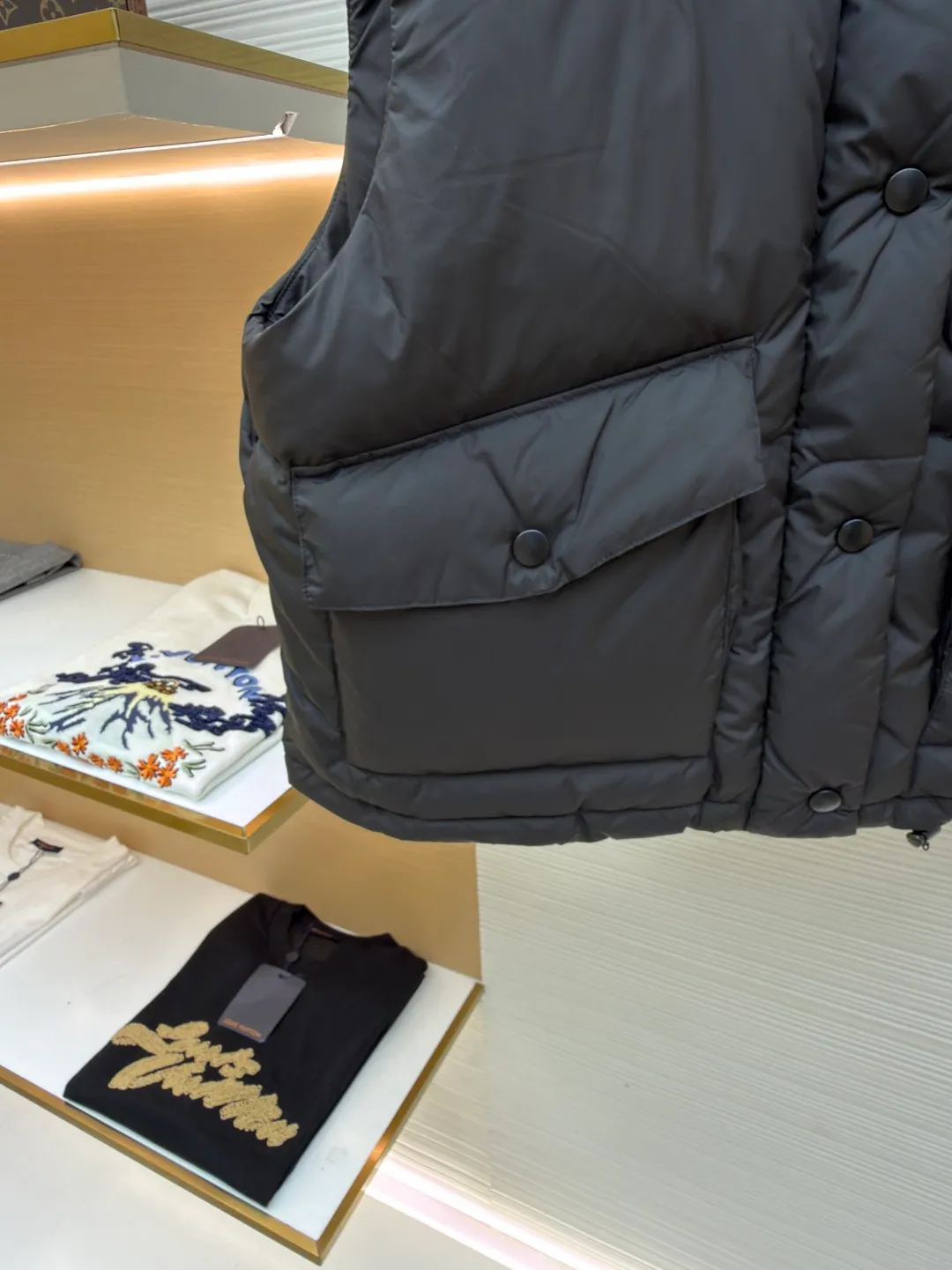 MIUMIU technology ponge down vest ●Item number: 1681319-C65 ●Material: white duck down fabric ●Technology: mechanical down filling ●Color: black ●Version: fitted version ●Weight: about 450 grams ●Size: S-M-L ●Description: This vest is made of lightweight and durable nylon fabric with down filling, taking into account warmth and fashion. The collar is made of genuine leather to improve the overall texture and warmth. The outer layer of high-density nylon is windproof and waterproof, lightweight and wear-resistant. The inner layer is filled with down, which has high fluffiness and warmth retention. It is made of national standard 90 white duck down and has a filling capacity of 190 grams to ensure excellent warmth retention. The down has been strictly screened and processed and is not easy to be drilled, ensuring durability. The letter pattern is displayed on the breast bag piece through glue printing. The printer scrapes the print 10 times to ensure the printing thickness, forming a micro-three-dimensional convex structure. The scraper pressure is even and the firmness is improved. After being cured at high temperature, the pigment is combined with the fabric fibers and is not easy to fall off due to friction. The overall wiring is straight and delicate, the fabric is comfortable and soft, and the color is consistent without color difference. It can be matched with the same style to create a fashionable look and control various occasions. Customized accessories, complete with three standards, same style for men and women!