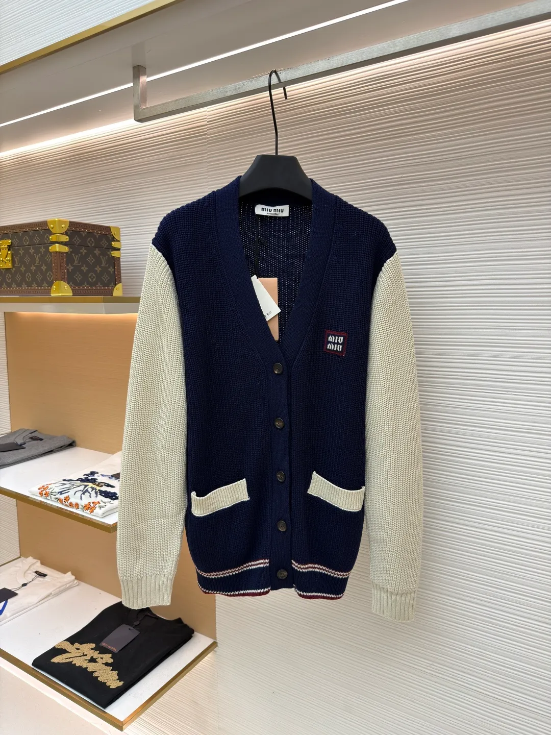 MIUMIU College Style Chest Logo Jacquard Sweater ●Original version: Purchased and developed for 26900 ●Item number: 1681494-A65 ●Fabric: wool blended fabric ●Technology: Knitted ●Color: off-white/navy blue ●Version: Fitted version ●Weight: about 785g ●Size: 42-44-46 ●Description: Made of 40% sheep soft 15% wool 45% cotton blended fabric, original dyed royal blue. Use 7 stitches to knit a multi-piece sewing plate. It uses horn buttons, each button has irregular horn patterns, and the chest label is made of pure cotton custom jacquard MiuMiu. Tennis-inspired details accent this cashmere and wool-blend cardigan. The distinctive ribbed pattern and oversized shape create a casual and elegant style. The overall wiring is straight and delicate, the fabric is comfortable and soft, and the color is consistent without color difference. It can be matched with the same style to create a fashionable look and control various occasions. Customized accessories, complete with three standards, same style for men and women!