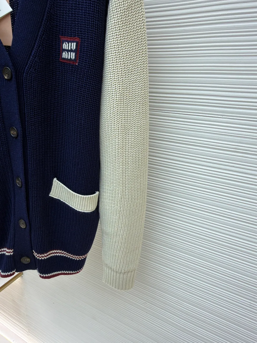 MIUMIU College Style Chest Logo Jacquard Sweater ●Original version: Purchased and developed for 26900 ●Item number: 1681494-A65 ●Fabric: wool blended fabric ●Technology: Knitted ●Color: off-white/navy blue ●Version: Fitted version ●Weight: about 785g ●Size: 42-44-46 ●Description: Made of 40% sheep soft 15% wool 45% cotton blended fabric, original dyed royal blue. Use 7 stitches to knit a multi-piece sewing plate. It uses horn buttons, each button has irregular horn patterns, and the chest label is made of pure cotton custom jacquard MiuMiu. Tennis-inspired details accent this cashmere and wool-blend cardigan. The distinctive ribbed pattern and oversized shape create a casual and elegant style. The overall wiring is straight and delicate, the fabric is comfortable and soft, and the color is consistent without color difference. It can be matched with the same style to create a fashionable look and control various occasions. Customized accessories, complete with three standards, same style for men and women!