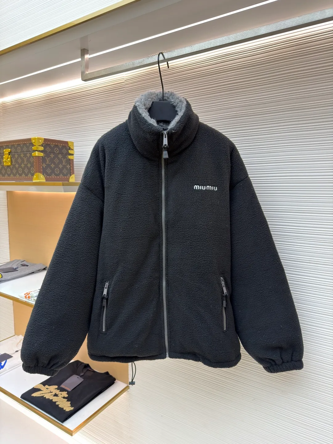 MIUMIU Polar Fleece Collar Down Jacket ●Original version: purchased and developed at 16999 ●Item number: 1681395-C65 ●Fabric: polar fleece fabric ●Technology: made on positioning cutting machine ●Color: black ●Version: fitted version ●Weight: about 945 grams ●Size: 38-40-42-44 ●Description: This jacket is made of high-quality polar fleece fabric and treated with a special fleece process. It feels soft and fluffy and has excellent warmth retention. The collar is made of imitation lambswool and is made through flocking technology, forming a texture contrast with the polar fleece fabric. The main zipper is a custom-made metal zipper, which is smooth and durable; the zippers of the zipper pockets on both sides are made of the same material as the main zipper, combining practicality and design. The brand logo adopts exquisite embroidery technology, and the stitching is fine and firm. The drawstring at the hem adopts a metal buckle and can be adjusted for tightness. The overall sewing adopts flat seam technology, the stitch spacing is even, and the seams of the body are smooth and snug. From the comfortable texture of the fabric to the craftsmanship of the details, it reflects the brand's dual pursuit of fashion and quality. It is a single product with both warmth and design. The overall wiring is straight and delicate, the fabric is comfortable and soft, and the color is consistent without color difference. It can be matched with the same style to create a fashionable look and control various occasions. Customized accessories, complete with three standards, same style for men and women!