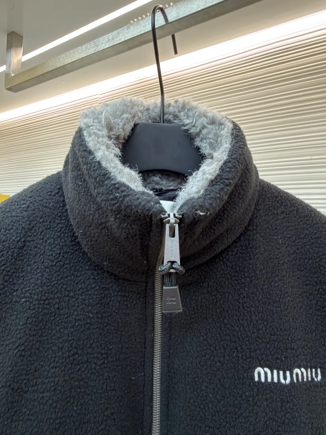 MIUMIU Polar Fleece Collar Down Jacket ●Original version: purchased and developed at 16999 ●Item number: 1681395-C65 ●Fabric: polar fleece fabric ●Technology: made on positioning cutting machine ●Color: black ●Version: fitted version ●Weight: about 945 grams ●Size: 38-40-42-44 ●Description: This jacket is made of high-quality polar fleece fabric and treated with a special fleece process. It feels soft and fluffy and has excellent warmth retention. The collar is made of imitation lambswool and is made through flocking technology, forming a texture contrast with the polar fleece fabric. The main zipper is a custom-made metal zipper, which is smooth and durable; the zippers of the zipper pockets on both sides are made of the same material as the main zipper, combining practicality and design. The brand logo adopts exquisite embroidery technology, and the stitching is fine and firm. The drawstring at the hem adopts a metal buckle and can be adjusted for tightness. The overall sewing adopts flat seam technology, the stitch spacing is even, and the seams of the body are smooth and snug. From the comfortable texture of the fabric to the craftsmanship of the details, it reflects the brand's dual pursuit of fashion and quality. It is a single product with both warmth and design. The overall wiring is straight and delicate, the fabric is comfortable and soft, and the color is consistent without color difference. It can be matched with the same style to create a fashionable look and control various occasions. Customized accessories, complete with three standards, same style for men and women!