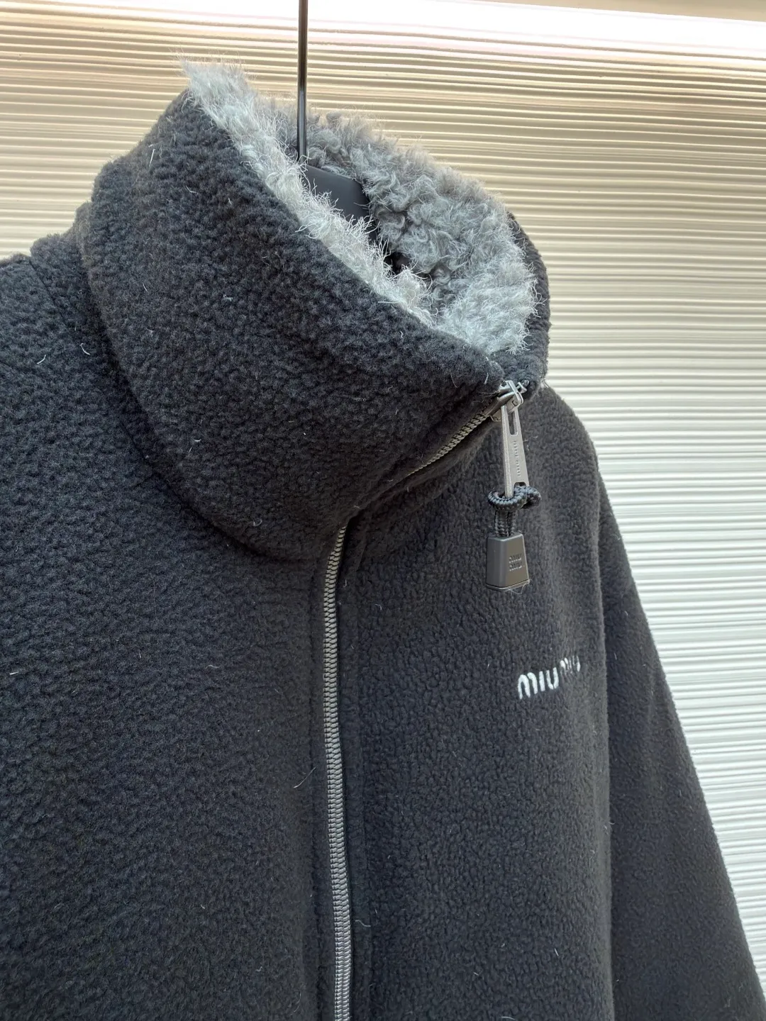 MIUMIU Polar Fleece Collar Down Jacket ●Original version: purchased and developed at 16999 ●Item number: 1681395-C65 ●Fabric: polar fleece fabric ●Technology: made on positioning cutting machine ●Color: black ●Version: fitted version ●Weight: about 945 grams ●Size: 38-40-42-44 ●Description: This jacket is made of high-quality polar fleece fabric and treated with a special fleece process. It feels soft and fluffy and has excellent warmth retention. The collar is made of imitation lambswool and is made through flocking technology, forming a texture contrast with the polar fleece fabric. The main zipper is a custom-made metal zipper, which is smooth and durable; the zippers of the zipper pockets on both sides are made of the same material as the main zipper, combining practicality and design. The brand logo adopts exquisite embroidery technology, and the stitching is fine and firm. The drawstring at the hem adopts a metal buckle and can be adjusted for tightness. The overall sewing adopts flat seam technology, the stitch spacing is even, and the seams of the body are smooth and snug. From the comfortable texture of the fabric to the craftsmanship of the details, it reflects the brand's dual pursuit of fashion and quality. It is a single product with both warmth and design. The overall wiring is straight and delicate, the fabric is comfortable and soft, and the color is consistent without color difference. It can be matched with the same style to create a fashionable look and control various occasions. Customized accessories, complete with three standards, same style for men and women!
