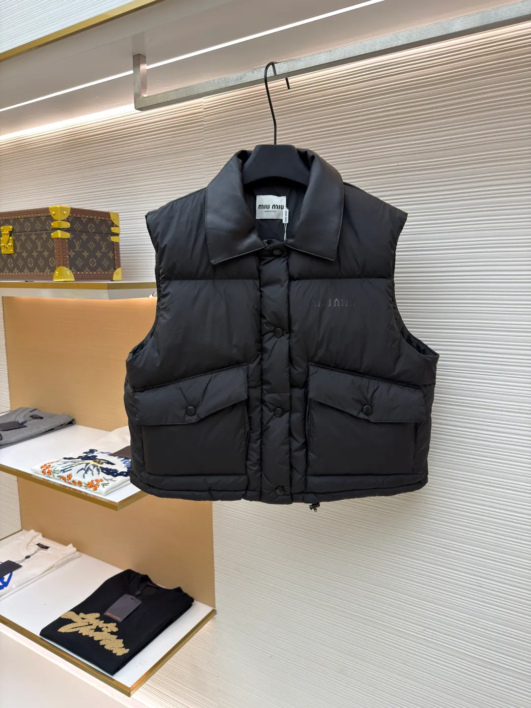 MIUMIU technology ponge down vest ●Item number: 1681319-C65 ●Material: white duck down fabric ●Technology: mechanical down filling ●Color: black ●Version: fitted version ●Weight: about 450 grams ●Size: S-M-L ●Description: This vest is made of lightweight and durable nylon fabric with down filling, taking into account warmth and fashion. The collar is made of genuine leather to improve the overall texture and warmth. The outer layer of high-density nylon is windproof and waterproof, lightweight and wear-resistant. The inner layer is filled with down, which has high fluffiness and warmth retention. It is made of national standard 90 white duck down and has a filling capacity of 190 grams to ensure excellent warmth retention. The down has been strictly screened and processed and is not easy to be drilled, ensuring durability. The letter pattern is displayed on the breast bag piece through glue printing. The printer scrapes the print 10 times to ensure the printing thickness, forming a micro-three-dimensional convex structure. The scraper pressure is even and the firmness is improved. After being cured at high temperature, the pigment is combined with the fabric fibers and is not easy to fall off due to friction. The overall wiring is straight and delicate, the fabric is comfortable and soft, and the color is consistent without color difference. It can be matched with the same style to create a fashionable look and control various occasions. Customized accessories, complete with three standards, same style for men and women!