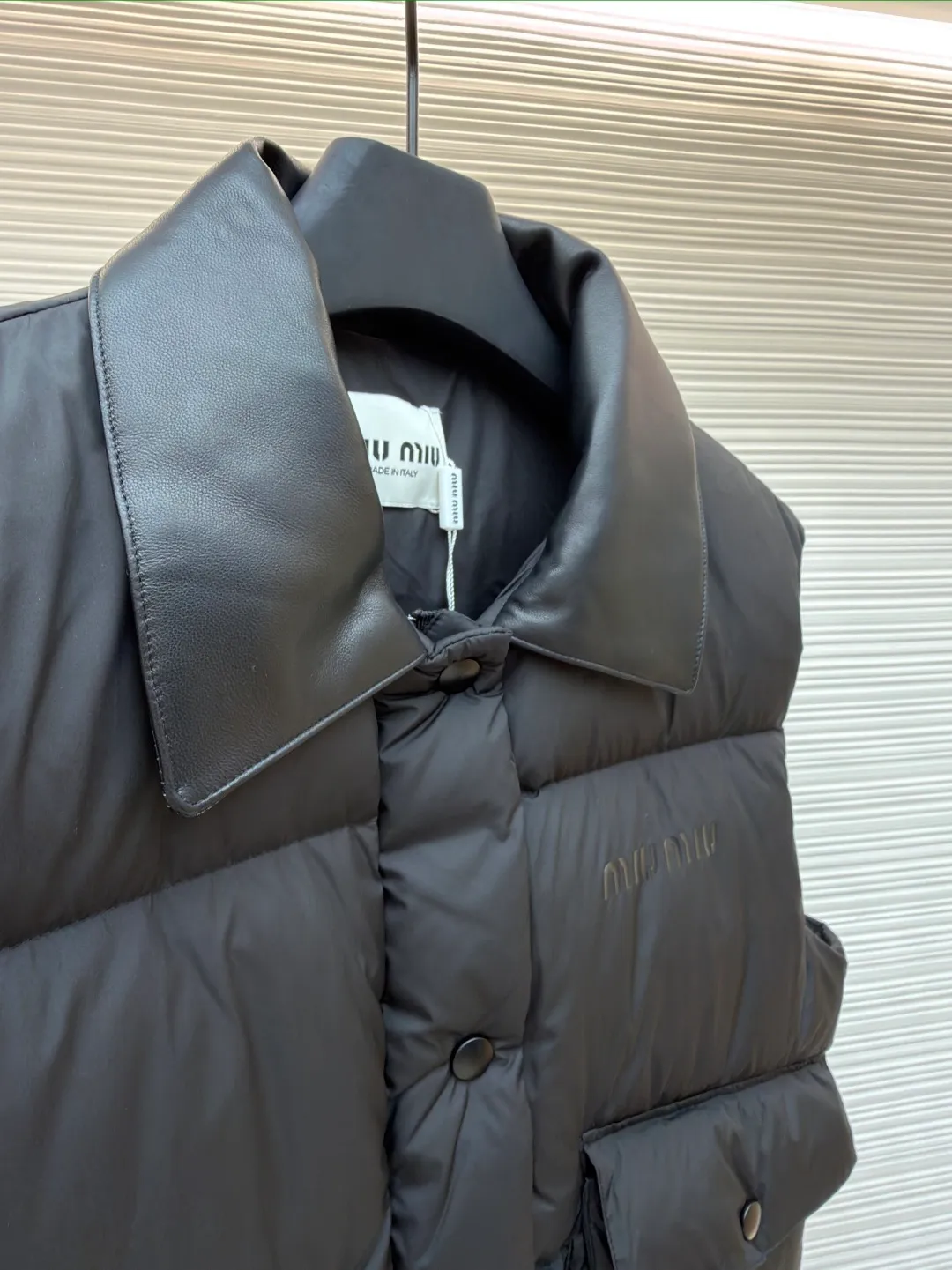 MIUMIU technology ponge down vest ●Item number: 1681319-C65 ●Material: white duck down fabric ●Technology: mechanical down filling ●Color: black ●Version: fitted version ●Weight: about 450 grams ●Size: S-M-L ●Description: This vest is made of lightweight and durable nylon fabric with down filling, taking into account warmth and fashion. The collar is made of genuine leather to improve the overall texture and warmth. The outer layer of high-density nylon is windproof and waterproof, lightweight and wear-resistant. The inner layer is filled with down, which has high fluffiness and warmth retention. It is made of national standard 90 white duck down and has a filling capacity of 190 grams to ensure excellent warmth retention. The down has been strictly screened and processed and is not easy to be drilled, ensuring durability. The letter pattern is displayed on the breast bag piece through glue printing. The printer scrapes the print 10 times to ensure the printing thickness, forming a micro-three-dimensional convex structure. The scraper pressure is even and the firmness is improved. After being cured at high temperature, the pigment is combined with the fabric fibers and is not easy to fall off due to friction. The overall wiring is straight and delicate, the fabric is comfortable and soft, and the color is consistent without color difference. It can be matched with the same style to create a fashionable look and control various occasions. Customized accessories, complete with three standards, same style for men and women!