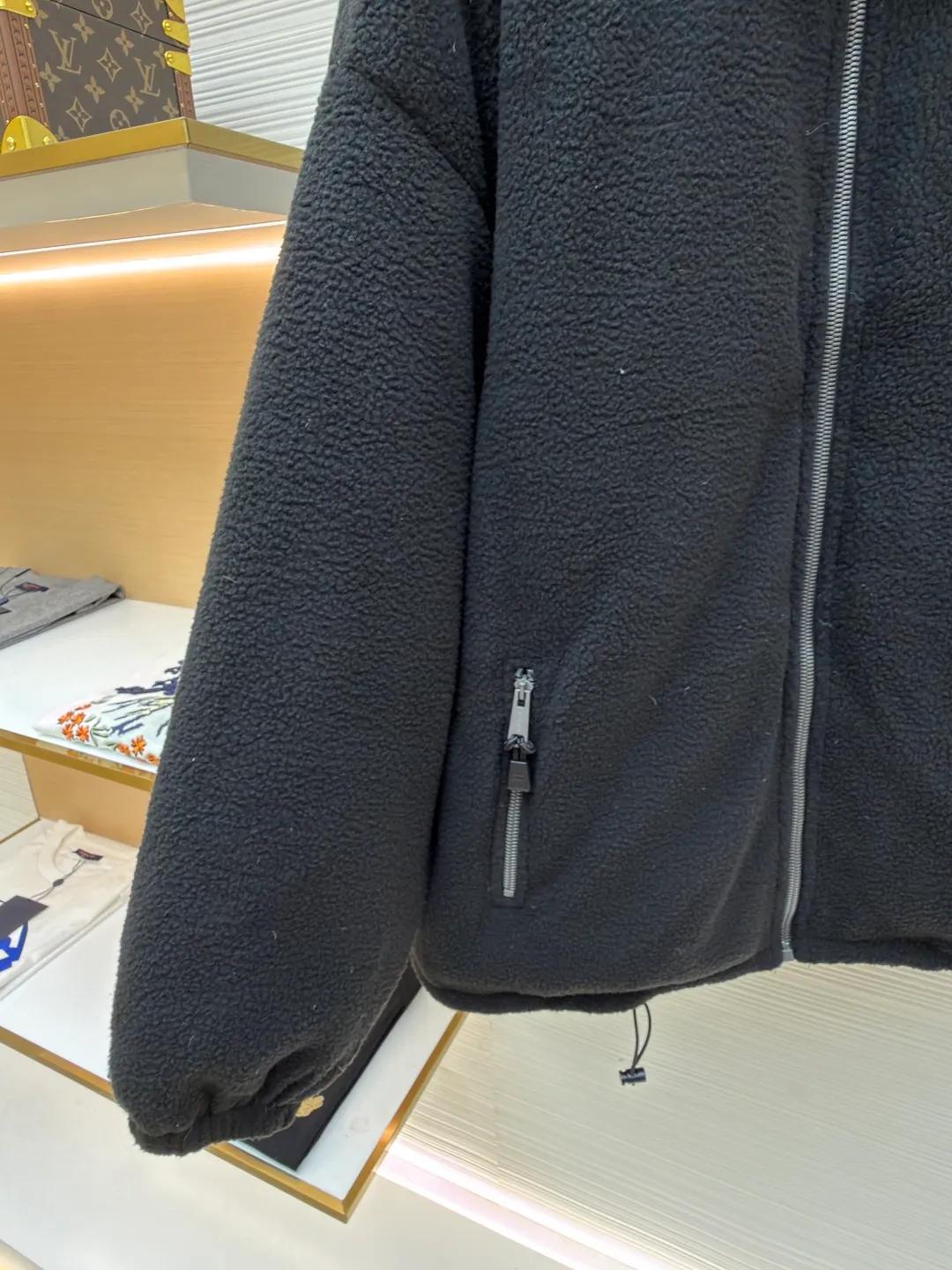 MIUMIU Polar Fleece Collar Down Jacket ●Original version: purchased and developed at 16999 ●Item number: 1681395-C65 ●Fabric: polar fleece fabric ●Technology: made on positioning cutting machine ●Color: black ●Version: fitted version ●Weight: about 945 grams ●Size: 38-40-42-44 ●Description: This jacket is made of high-quality polar fleece fabric and treated with a special fleece process. It feels soft and fluffy and has excellent warmth retention. The collar is made of imitation lambswool and is made through flocking technology, forming a texture contrast with the polar fleece fabric. The main zipper is a custom-made metal zipper, which is smooth and durable; the zippers of the zipper pockets on both sides are made of the same material as the main zipper, combining practicality and design. The brand logo adopts exquisite embroidery technology, and the stitching is fine and firm. The drawstring at the hem adopts a metal buckle and can be adjusted for tightness. The overall sewing adopts flat seam technology, the stitch spacing is even, and the seams of the body are smooth and snug. From the comfortable texture of the fabric to the craftsmanship of the details, it reflects the brand's dual pursuit of fashion and quality. It is a single product with both warmth and design. The overall wiring is straight and delicate, the fabric is comfortable and soft, and the color is consistent without color difference. It can be matched with the same style to create a fashionable look and control various occasions. Customized accessories, complete with three standards, same style for men and women!