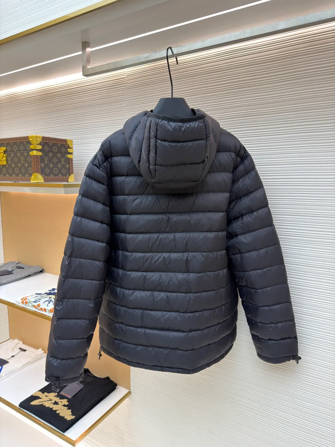 MIU MIU hooded down jacket ●Item number: 1681314-C55 ●Material: white duck down fabric ●Technology: mechanical down filling ●Color: black ●Version: fitted version ●Weight: about 615 grams ●Size: S-M-L-XL ●Description: This is a light down jacket from the MiuMiu brand. Its craftsmanship details are as follows: It is made of exquisite pongé fabric made of 100% recycled polyester fiber. This fabric has good windproof performance, and at the same time has a delicate texture and a high-end luster. It has high fluffiness, excellent warmth retention and is very light overall, allowing the wearer to gain warmth without any heavy burden. It has a three-dimensional cut and a neat silhouette. Precision stitching technology is used during sewing to form regular quilting lines, which not only serves to fix the down, but also enhances the structure and design of the garment. The stitches are fine and even, and the seams are smooth, reflecting the exquisite craftsmanship of garment making. Equipped with a customized wax zipper, the zipper is smooth and durable, and the zipper puller has brand details and a high-quality feel. The hooded design fits the head and increases warmth; the drawstring cuffs can be adjusted according to needs to prevent cold wind from entering; the elastic drawstring at the hem can adjust the looseness of the hem, improving the comfort and practicality of wearing; there is the brand's embroidered logo on the chest, with fine craftsmanship and highlighting the brand identity.