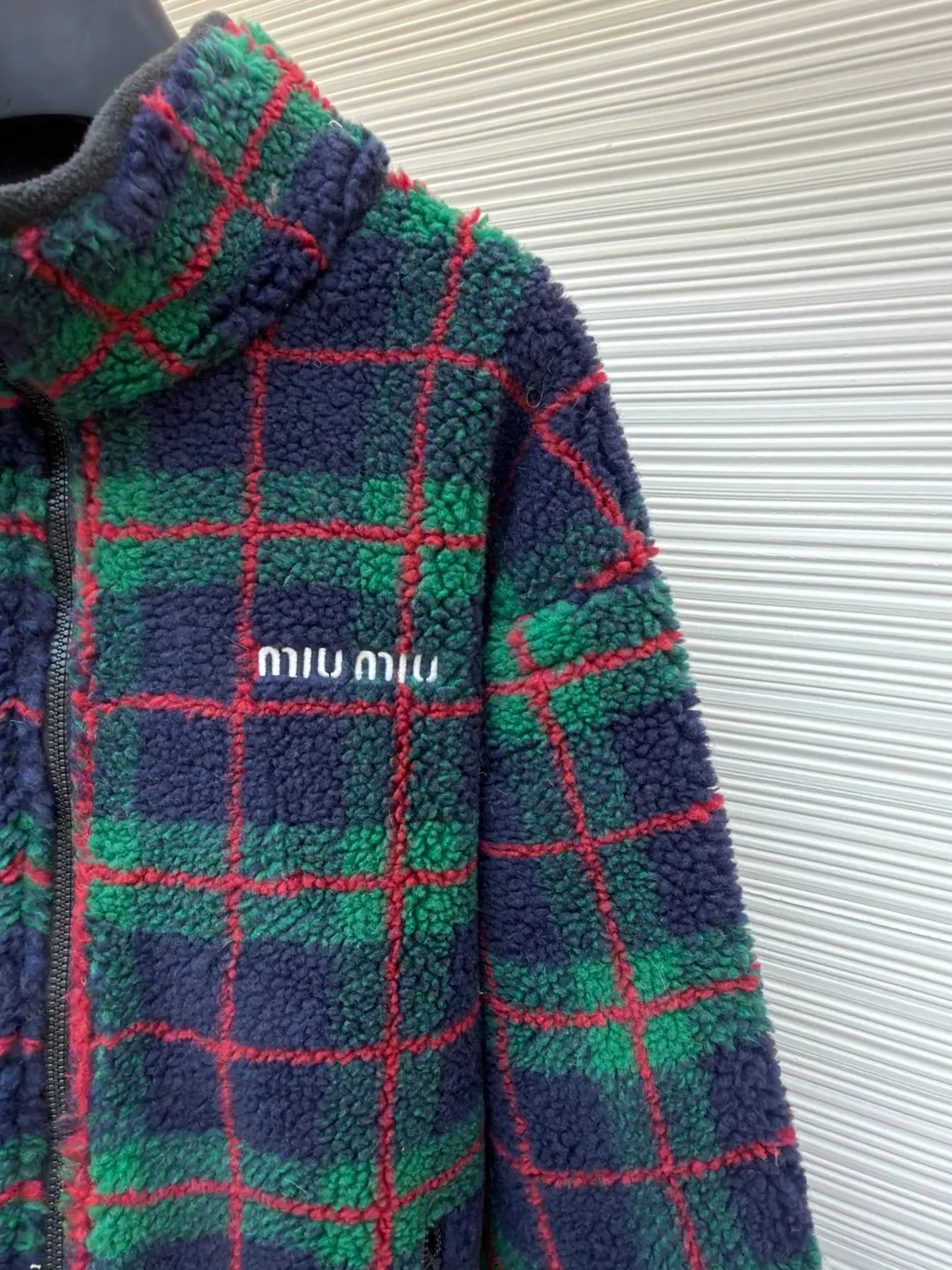 MIUMIU sherpa plaid embroidered zipper jacket ●Original version: Purchased and developed in 20100 ●Item number: 1682024-B25 ●Fabric: wool fabric ●Technology: embroidery production ●Color: red and green ●Type: fitted version ●Weight: about 810 grams ●Size: S-M-L-XL ●Description: Made of 80% wool, 20% cotton. This fabric is originally woven and dyed, 100% restored. The lining pocket fabric is made of 100% nylon material and the back collar is matched with 100% wool teddy fleece. The zipper is made of nylon and rubber teeth, and the pull teeth are made of European rubber teeth. The hem has an original engraved elastic buckle. The embroidery adopts 3D three-dimensional embroidery technology, and the embroidered logo is full and three-dimensional. Presenting high-end visual effects. The classic jacket is reinterpreted here, with wool added for added thickness and softness. The classic plaid pattern draws inspiration from menswear style, reinterpreting the style code of sporty femininity. Oversize version. Unlined long-sleeved stand collar. Front zippered side pockets. Double-ended crochet hem. Embroidered logo. The overall wiring is straight and delicate, the fabric is comfortable and soft, and the color is consistent without color difference. It can be matched with the same style to create a fashionable look and control various occasions. Customized accessories, complete with three standards, same style for men and women!