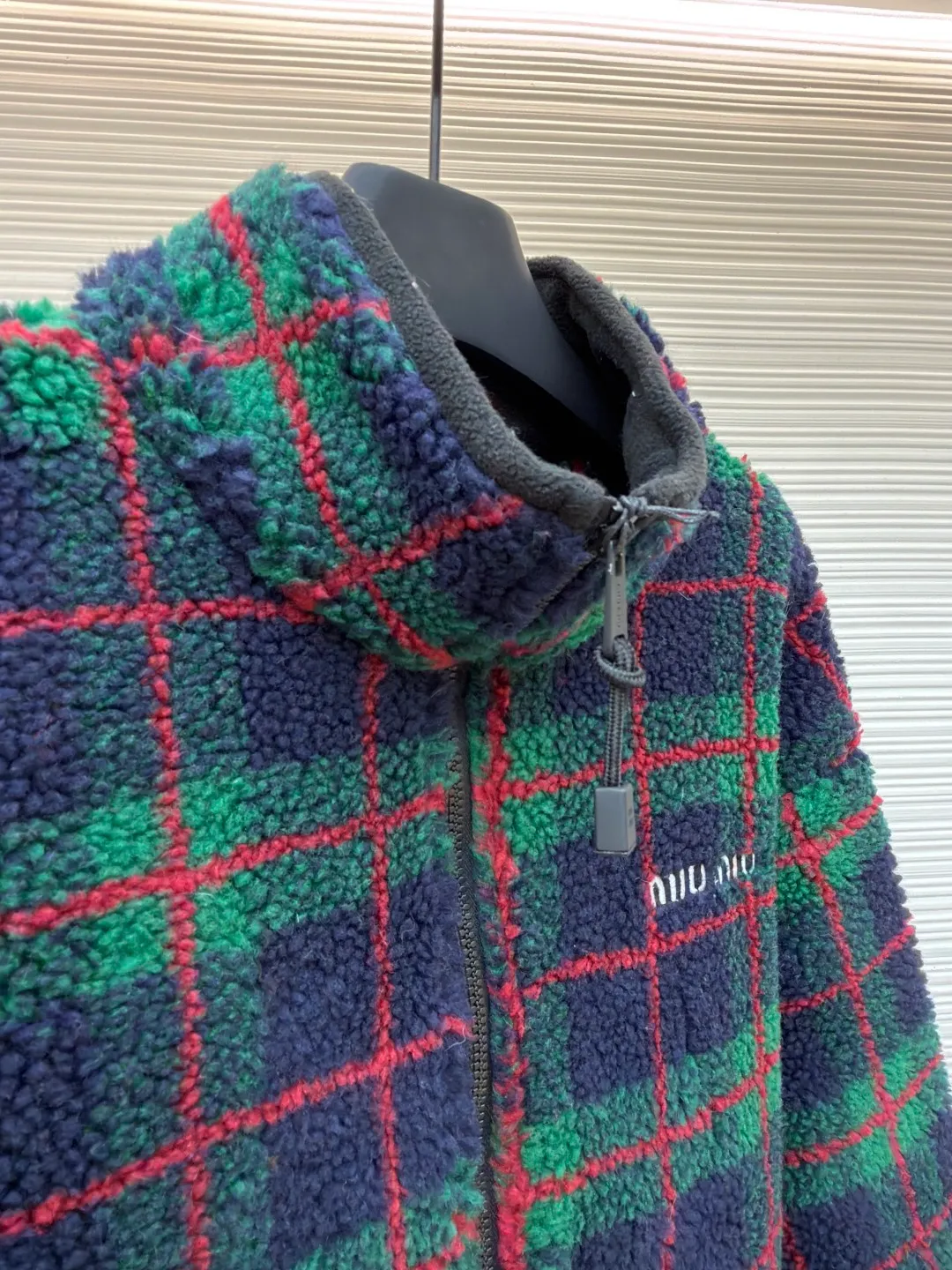 MIUMIU sherpa plaid embroidered zipper jacket ●Original version: Purchased and developed in 20100 ●Item number: 1682024-B25 ●Fabric: wool fabric ●Technology: embroidery production ●Color: red and green ●Type: fitted version ●Weight: about 810 grams ●Size: S-M-L-XL ●Description: Made of 80% wool, 20% cotton. This fabric is originally woven and dyed, 100% restored. The lining pocket fabric is made of 100% nylon material and the back collar is matched with 100% wool teddy fleece. The zipper is made of nylon and rubber teeth, and the pull teeth are made of European rubber teeth. The hem has an original engraved elastic buckle. The embroidery adopts 3D three-dimensional embroidery technology, and the embroidered logo is full and three-dimensional. Presenting high-end visual effects. The classic jacket is reinterpreted here, with wool added for added thickness and softness. The classic plaid pattern draws inspiration from menswear style, reinterpreting the style code of sporty femininity. Oversize version. Unlined long-sleeved stand collar. Front zippered side pockets. Double-ended crochet hem. Embroidered logo. The overall wiring is straight and delicate, the fabric is comfortable and soft, and the color is consistent without color difference. It can be matched with the same style to create a fashionable look and control various occasions. Customized accessories, complete with three standards, same style for men and women!