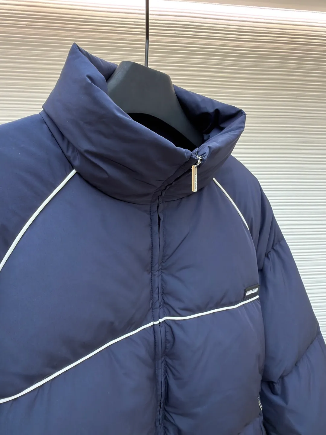 MIUMIU logo down jacket ●Original version: purchased and developed at 18695 ●Item number: 1861323-C95 ●Fabric: white duck down fabric ●Technology: mechanical down filling ●Color: navy ●Type: fitted version ●Weight: about 810 grams ●Size: 46-48-50-52 ●Description: Different from ordinary fabrics, custom-developed high-count and high-density woven fabrics. Imported computerized down filling equipment is used to ensure that the amount of down filling in each independent quilting grid is accurate and even, avoiding local holes or agglomerations, thereby ensuring the overall flatness, uniformity of warmth and long-lasting fluffiness of the down jacket. From the treatment of the interior, the firmness of the stitching of the zippers, to the precise positioning of decorative elements such as logos, the factory's craftsmanship ensures that the entire piece has impeccable finish and durable quality, making it a long-term wardrobe treasure worth owning. The overall wiring is straight and delicate, the fabric is comfortable and soft, and the color is consistent without color difference. It can be matched with the same style to create a fashionable look and control various occasions. Customized accessories, complete with three standards, same style for men and women!