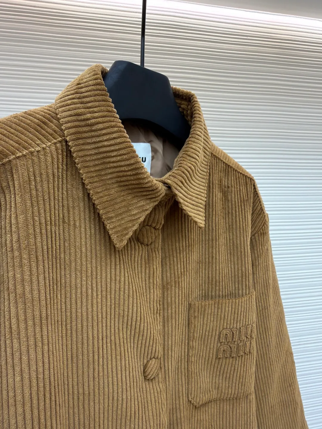 MIU MIU corduroy texture down cotton jacket ●Original version: 25400 purchased and developed ●Item number: 1681328-B50 ●Fabric: corduroy fabric ●Technology: embroidery production ●Color: brown ●Version: fitted version ●Weight: about 720 grams ●Size: 38-40-42 ●Description: Made of high-quality corduroy fabric, the velvet strips are full and regularly arranged. Through a special weaving process, the fabric has a soft touch and good warmth retention, while showing a retro and high-end texture. The "MiuMiu" brand logo on the chest pocket uses three-dimensional embroidery technology. The embroidery stitches are fine and even, the pattern outline is clear, and it is perfectly integrated with the corduroy fabric, which not only highlights the brand identity, but also improves the overall craftsmanship sophistication. It adopts a loose silhouette and is in line with the current fashion trend. It is comfortable and tolerant to wear. The flat stitching process is used during sewing, the stitching is straight, the stitch length is even, and the splicing of the garment pieces is smooth and snug, reflecting the exquisite level of garment making. The overall wiring is straight and delicate, the fabric is comfortable and soft, and the color is consistent without color difference. It can be matched with the same style to create a fashionable look and control various occasions. Customized accessories, complete with three standards, same style for men and women!