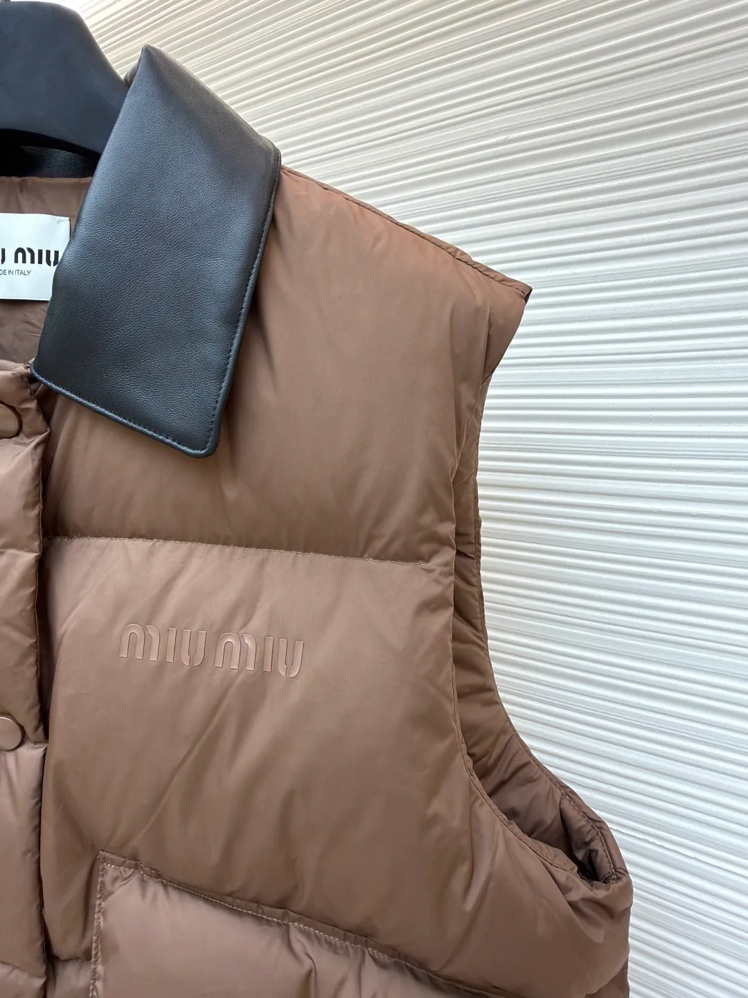 MIUMIU technology ponge down vest [Women's clothing] ●Item number: 1681115-C65 ●Material: white duck down fabric ●Technology: glue printing ●Version: fitted version ●Weight: about 425 grams ●Size: S-M-L ●Description: This vest is made of lightweight and durable nylon fabric with down filling, taking into account both warmth and fashion. The collar is made of genuine leather to enhance the overall texture and warmth. The outer layer of high-density nylon is windproof and waterproof, light and wear-resistant, and the inner layer is filled with down, which has high fluffiness and strong warmth retention. It is made of national standard 90 white duck down and has a filling capacity of 190 grams to ensure excellent warmth retention. The down has been strictly screened and processed and is not easy to be drilled, ensuring durability. The letter pattern is displayed on the breast bag piece through glue printing. The printer scrapes the print 10 times to ensure the printing thickness, forming a micro-three-dimensional convex structure. The scraper pressure is even and the firmness is improved. After being cured at high temperature, the pigment is combined with the fabric fibers and is not easy to fall off due to friction. The overall wiring is straight and delicate, the fabric is comfortable and soft, and the color is consistent without color difference. It can be matched with the same style to create a fashionable look and control various occasions. Customized accessories, complete with three standards, same style for men and women!