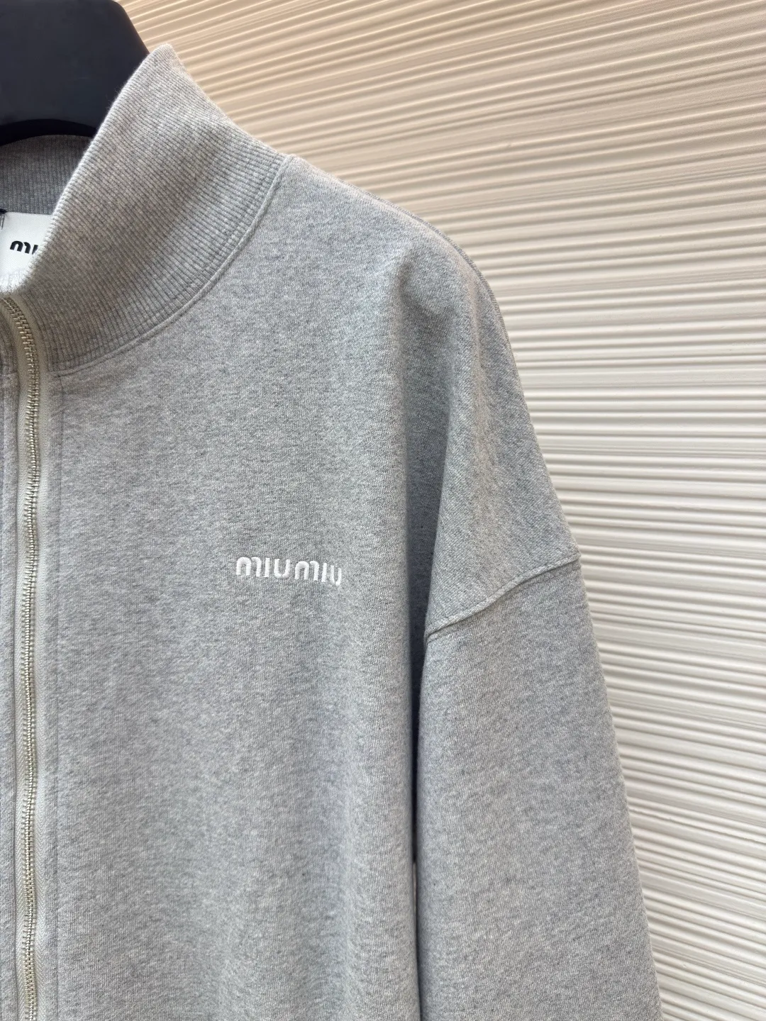 MIUMIU zipper embroidered sweatshirt jacket ●Authentic product: Purchased and developed for 17300 ●Item number: 1680645-A95 ●Fabric: sheepfold fabric ●Technology: embroidery production ●Version: Fitted version ●Weight: about 900g ●Size: 36-38-40-42 ●Description: Made of 380g terry, custom-woven Xinjiang cotton yarn. The thread is made of matching 1*1 double yarn and dyed in the same vat. The embroidery uses 3D three-dimensional embroidery technology and is embellished with miuiu, showing a simple and high-end style. Full-width opening pocket with zipper, double zipper design at the pocket, and No. 5 electroplated bright silver-white slider. The hem has a hanging buckle and a MiuMiu engraved logo on the face. Combining style and performance, this sweatshirt features a relaxed fit that plays with proportions and a modern aesthetic. Oversize fit. Long sleeves with rib knit cuffs. Stand collar. Front zip closure. Stretch hem. Embroidered logo. The overall wiring is straight and delicate, the fabric is comfortable and soft, and the color is consistent without color difference. It can be matched with the same style to create a fashionable look and control various occasions. Customized accessories, complete with three standards, same style for men and women!