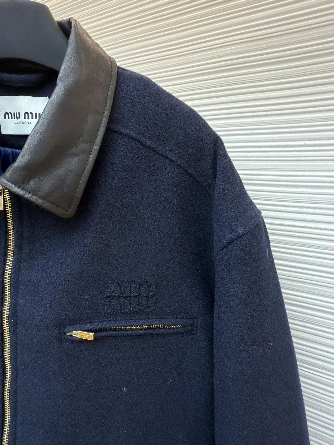 MIUMIU shearling collar embroidered woolen cotton jacket ●Original version: 43702 purchased and developed ●Item number: 1681799-c75 ●Fabric: wool washed fabric ●Technology: laser cutting and shaping ●Color: navy blue ●Version: fitted version ●Weight: about 1440 grams ●Size: 46-48-50-52 ●Description: Made of washed wool fabric treated with special finishing process. The wool fiber becomes more supple through washing, which greatly reduces the irritation that traditional wool may cause, allowing it to be worn directly next to the body with high comfort. At the same time, a uniform and slight velvety layer is formed on the surface. This "distressed" effect gives the fabric a casual, casual, unintentional fashion style, avoiding the overly formal and stiff feeling of traditional wool clothing. The natural elasticity and resilience of wool fiber remain after washing, making the clothes less likely to deform and maintaining a good silhouette for a long time. The letter embroidery patches are laser cut and shaped to create an embossed texture and clear fonts. Each patch undergoes 5 layers of anti-wrinkle treatment to ensure that it retains its original shape after washing, enhancing visual recognition. Using quilted cannage pattern, the seamstress precisely adjusts the speed of the machine and stitch density, so that the stitches are smooth and even during the operation. After completion, regular diagonal quilting lines will be formed, which will inadvertently enhance the overall texture when putting it on and taking it off. The overall wiring is straight and delicate, the fabric is comfortable and soft, and the color is consistent without color difference. It can be matched with the same style to create a fashionable look and control various occasions. Customized accessories, complete with three standards, same style for men and women!