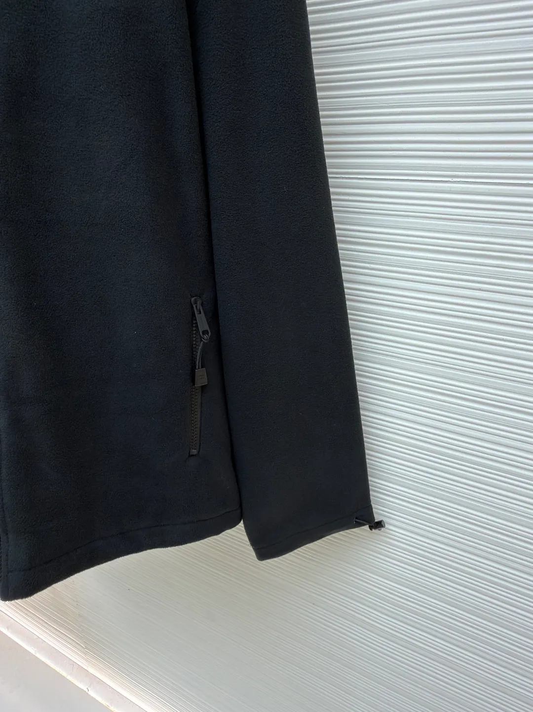 MIUMIU polar fleece embroidered jacket ●Original version: purchased and developed by 14859 ●Item number: 1680859-A95 ●Fabric: polar fleece fabric ●Technology: embroidery production ●Version: fitted version ●Weight: about 585 grams ●Size: 46-48-50-52 ●Description: The polyester filament passes through a circular knitting machine, and the warp and weft yarns are woven into each other into a double-sided knitted structure. The front and back are flat loops. The polar fleece fabric is formed after a series of processes such as dyeing, raising, carding, shearing, and polarization. The suede texture is soft and the fiber characteristics make it almost non-absorbent. It can quickly drain sweat to the outer layer of the fabric and evaporate quickly, maintaining good breathability. The suede surface can lock the air and form a stagnant air layer around the body, effectively preventing heat loss and providing good warmth retention properties. By setting an extremely high stitch density on the computer embroidery machine, the fabric and backing are tightly fixed on the frame of the embroidery machine, with even and just the right tension. The double-axis linear guide drives the embroidery frame, and the frame moving accuracy can reach 0.01mm/P, ensuring precise positioning. The overall wiring is straight and delicate, the fabric is comfortable and soft, and the color is consistent without color difference. It can be matched with the same style to create a fashionable look and control various occasions. Customized accessories, complete with three standards, same style for men and women!