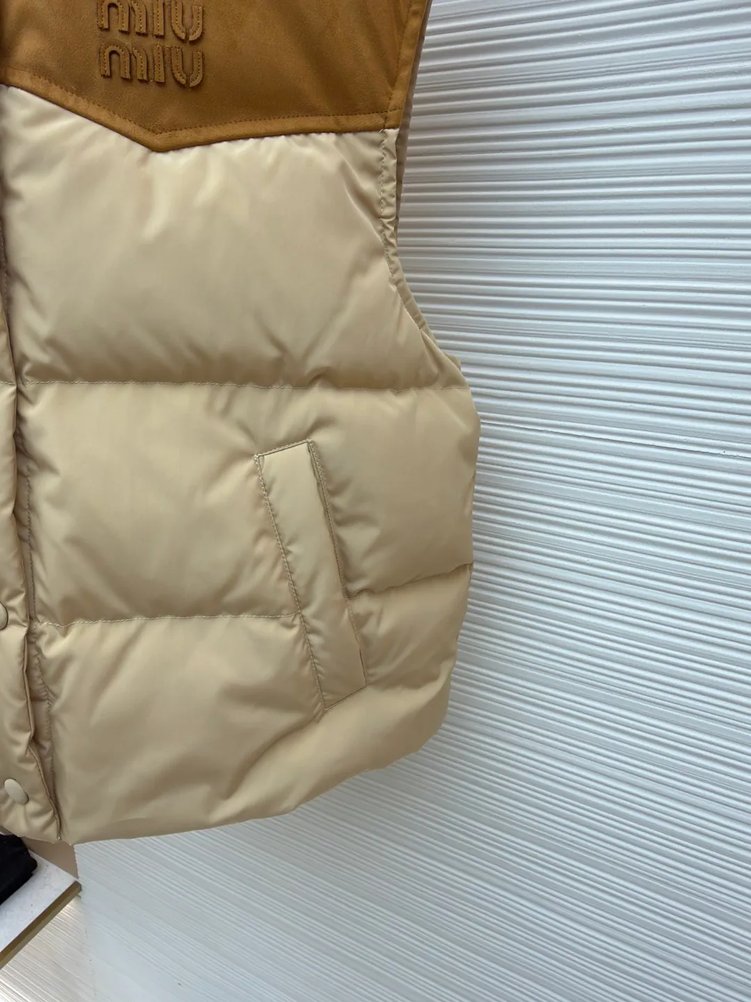 MIUMIU flocked stitching lapel vest ●Original version: Purchased and developed by 26615 ●Item number: 1681922-B50 ●Fabric: white duck down fabric ●Technology: embossed flocking ●Color: Khaki ●Version: Fitted version ●Weight: about 505 grams ●Size: S-M-L ●Description: This style is Miu Miu-style patchwork vest uses collision splicing technology: the main body is made of high-density matte nylon fabric, which is wind-resistant and anti-sand velvet; the collar and chest area are spliced with fine suede, and the texture contrast is enhanced by diagonal stitching. The filling is made of high-fill white duck down, and the segmented down filling process ensures an even amount of down in each grid, with a fill power of 600+; the placket is designed with metal snaps and a built-in concealed buckle for double temperature locking. The "MIU MIU" logo on the front chest adopts embossed flocking technology, which has a three-dimensional touch and is not easy to fall off; the cuffs and hem are elasticized to fit the body shape. The overall stitching uses anti-drilling velvet hemming needles, and the pockets are obliquely inserted invisible pockets, taking into account both beauty and practicality. It is a fashionable style that is lightweight and warm in autumn and winter. The overall wiring is straight and delicate, the fabric is comfortable and soft, and the color is consistent without color difference. It can be matched with the same style to create a fashionable look and control various occasions. Customized accessories, complete with three standards, same style for men and women!