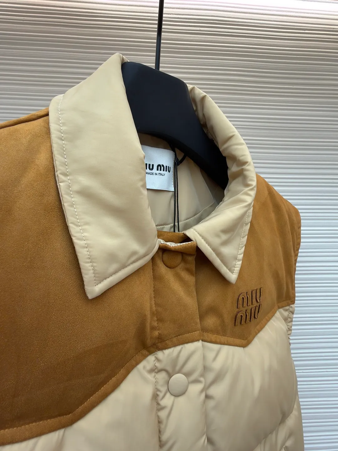 MIUMIU flocked stitching lapel vest ●Original version: Purchased and developed by 26615 ●Item number: 1681922-B50 ●Fabric: white duck down fabric ●Technology: embossed flocking ●Color: Khaki ●Version: Fitted version ●Weight: about 505 grams ●Size: S-M-L ●Description: This style is Miu Miu-style patchwork vest uses collision splicing technology: the main body is made of high-density matte nylon fabric, which is wind-resistant and anti-sand velvet; the collar and chest area are spliced with fine suede, and the texture contrast is enhanced by diagonal stitching. The filling is made of high-fill white duck down, and the segmented down filling process ensures an even amount of down in each grid, with a fill power of 600+; the placket is designed with metal snaps and a built-in concealed buckle for double temperature locking. The "MIU MIU" logo on the front chest adopts embossed flocking technology, which has a three-dimensional touch and is not easy to fall off; the cuffs and hem are elasticized to fit the body shape. The overall stitching uses anti-drilling velvet hemming needles, and the pockets are obliquely inserted invisible pockets, taking into account both beauty and practicality. It is a fashionable style that is lightweight and warm in autumn and winter. The overall wiring is straight and delicate, the fabric is comfortable and soft, and the color is consistent without color difference. It can be matched with the same style to create a fashionable look and control various occasions. Customized accessories, complete with three standards, same style for men and women!