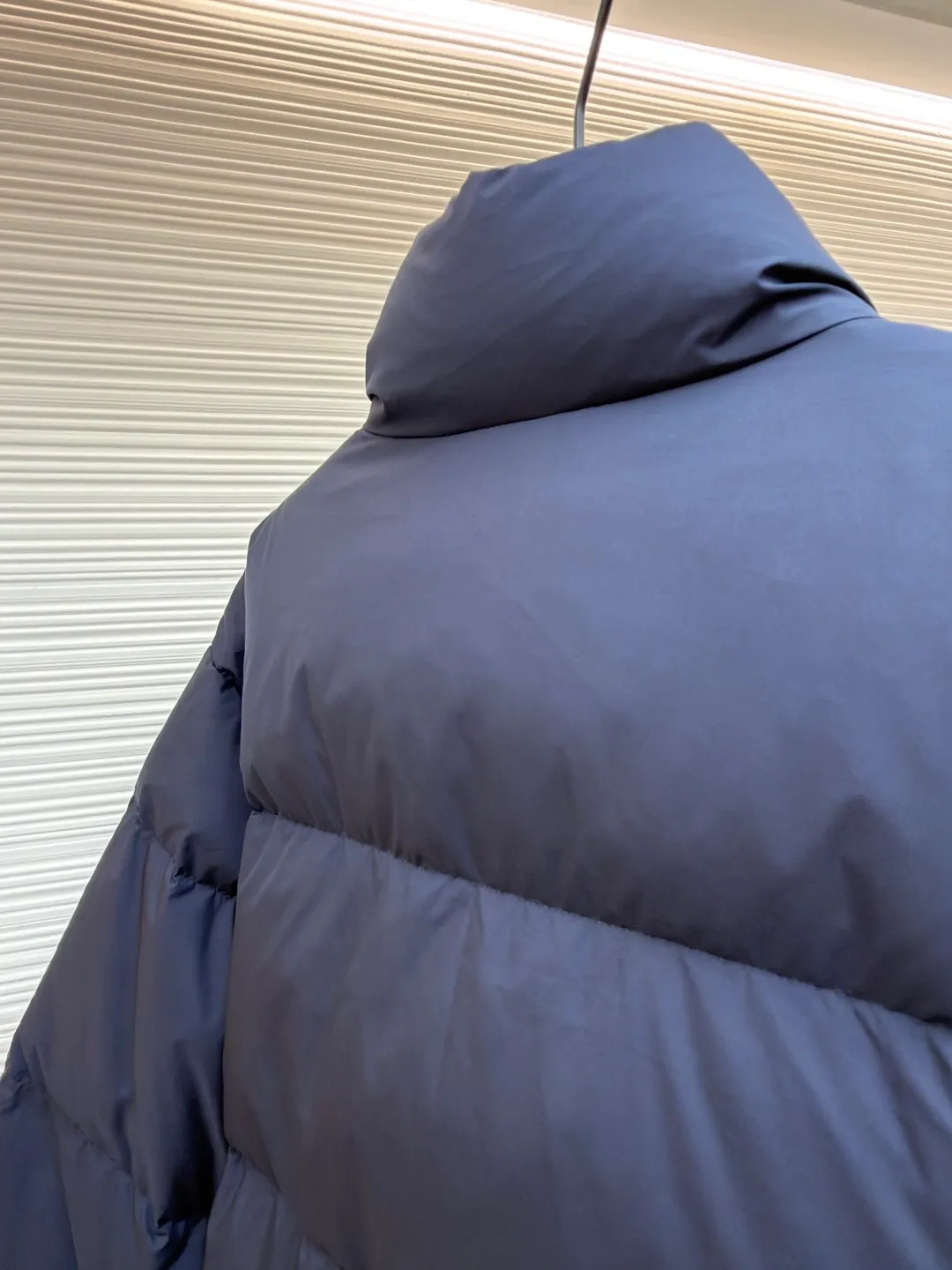 MIUMIU reversible stand collar down jacket ●Original version: purchased and developed by 21060 ●Item number: 1681385-D05 ●Fabric: white duck down fabric ●Technology: mechanical down filling ●Color: navy/khaki ●Version: fitted version ●Weight: about 675 grams ●Size: 36-38-40-42 ●Description: The filling is white duck down with 90% down content, which is one of the gold standards of down quality. "90% down content" means that the down content is extremely high and there are very few impurities such as feather stalks. The down tufts can capture more air and form an efficient thermal insulation layer, thus providing several times the loft and warmth of ordinary down while being lighter in weight. In the double-sided structure, ensuring that the down is evenly distributed between the two layers of fabric without clumping is the core challenge of the down filling process. The stand-up collar design not only improves the neatness of the shape, but also enhances the windproof and warm performance of the neck. Its internal structure needs to be stiff enough to maintain a three-dimensional shape, while at the same time ensuring the comfort of contact with the skin. The precision stitching in conjunction with the overall design not only plays a role in fixing the down and preventing displacement, but the uniformity, tension and pattern of the stitches have become important decorative elements, reflecting rigorous industrial aesthetics. The overall wiring is straight and delicate, the fabric is comfortable and soft, and the color is consistent without color difference. It can be matched with the same style to create a fashionable look and control various occasions. Customized accessories, complete with three standards, same style for men and women!