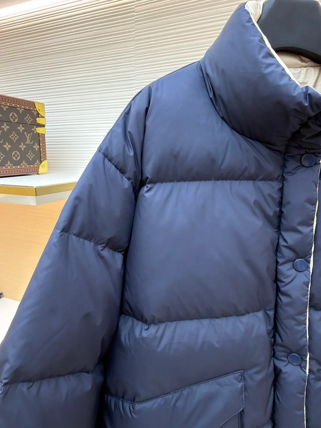 MIUMIU reversible stand collar down jacket ●Original version: purchased and developed by 21060 ●Item number: 1681385-D05 ●Fabric: white duck down fabric ●Technology: mechanical down filling ●Color: navy/khaki ●Version: fitted version ●Weight: about 675 grams ●Size: 36-38-40-42 ●Description: The filling is white duck down with 90% down content, which is one of the gold standards of down quality. "90% down content" means that the down content is extremely high and there are very few impurities such as feather stalks. The down tufts can capture more air and form an efficient thermal insulation layer, thus providing several times the loft and warmth of ordinary down while being lighter in weight. In the double-sided structure, ensuring that the down is evenly distributed between the two layers of fabric without clumping is the core challenge of the down filling process. The stand-up collar design not only improves the neatness of the shape, but also enhances the windproof and warm performance of the neck. Its internal structure needs to be stiff enough to maintain a three-dimensional shape, while at the same time ensuring the comfort of contact with the skin. The precision stitching in conjunction with the overall design not only plays a role in fixing the down and preventing displacement, but the uniformity, tension and pattern of the stitches have become important decorative elements, reflecting rigorous industrial aesthetics. The overall wiring is straight and delicate, the fabric is comfortable and soft, and the color is consistent without color difference. It can be matched with the same style to create a fashionable look and control various occasions. Customized accessories, complete with three standards, same style for men and women!