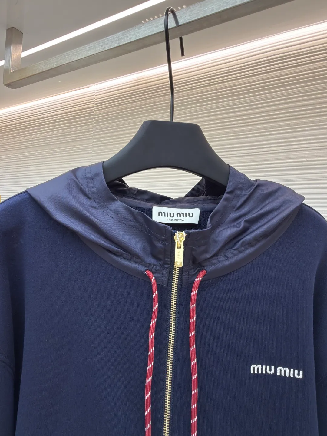 MIUMIU embroidered hooded sweatshirt ●Original version: purchased and developed by 13979 ●Item number: 1680807-B05 ●Fabric: fish scale fabric ●Technology: embroidery production ●Version: fitted version ●Weight: about 790 grams ●Size: S-M-L-XL ●Description: A single-sided fish-scale fabric woven with cotton as the base. The front is a smooth knitted surface, and the skin-contacting surface is formed into three-dimensional terry by the floating thread knitting technology of the knitting machine, which increases the fluffiness and has a delicate touch. The terry structure absorbs a large amount of water and evaporates quickly, so it is not easy to loosen and deform after repeated washing. The hat body and side pockets are made of nylon fabric, which is wear-resistant and has good wind resistance as the hat body. The 2*2 ribs formed by alternating longitudinal rows of front coils and longitudinal rows of back coils are still very elastic and have wide textures that fit the wrists and waist without a sense of restraint. The gaps between the coils allow air circulation without losing warmth. By actively interfering with the shrinkage potential of cotton fibers, the fabric is able to transition from changeable to stable, improving dimensional stability while being less prone to deformation and wrinkles. The high-precision calculation program system of the computerized embroidery machine controls the movement of the embroidery frame in the X/Y direction. At the same time, the needle shuttles up and down to embroider according to the set path. It automatically completes thread trimming, thread jumping and other actions to form a stitch track. It automatically adjusts the upper and lower thread tension to ensure that the stitches are smooth and free of floating threads, forming a high-precision letter pattern. The overall wiring is straight and delicate, the fabric is comfortable and soft, and the color is consistent without color difference. It can be matched with the same style to create a fashionable look and control various occasions. Customized accessories, complete with three standards, same style for men and women!