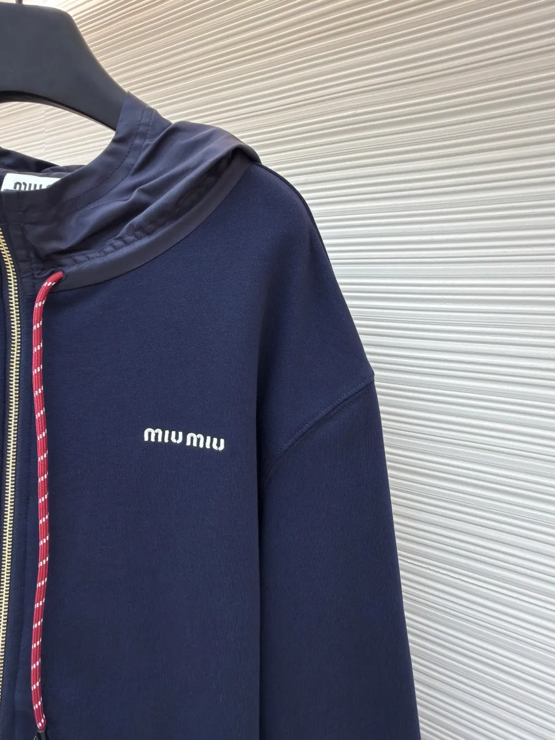 MIUMIU embroidered hooded sweatshirt ●Original version: purchased and developed by 13979 ●Item number: 1680807-B05 ●Fabric: fish scale fabric ●Technology: embroidery production ●Version: fitted version ●Weight: about 790 grams ●Size: S-M-L-XL ●Description: A single-sided fish-scale fabric woven with cotton as the base. The front is a smooth knitted surface, and the skin-contacting surface is formed into three-dimensional terry by the floating thread knitting technology of the knitting machine, which increases the fluffiness and has a delicate touch. The terry structure absorbs a large amount of water and evaporates quickly, so it is not easy to loosen and deform after repeated washing. The hat body and side pockets are made of nylon fabric, which is wear-resistant and has good wind resistance as the hat body. The 2*2 ribs formed by alternating longitudinal rows of front coils and longitudinal rows of back coils are still very elastic and have wide textures that fit the wrists and waist without a sense of restraint. The gaps between the coils allow air circulation without losing warmth. By actively interfering with the shrinkage potential of cotton fibers, the fabric is able to transition from changeable to stable, improving dimensional stability while being less prone to deformation and wrinkles. The high-precision calculation program system of the computerized embroidery machine controls the movement of the embroidery frame in the X/Y direction. At the same time, the needle shuttles up and down to embroider according to the set path. It automatically completes thread trimming, thread jumping and other actions to form a stitch track. It automatically adjusts the upper and lower thread tension to ensure that the stitches are smooth and free of floating threads, forming a high-precision letter pattern. The overall wiring is straight and delicate, the fabric is comfortable and soft, and the color is consistent without color difference. It can be matched with the same style to create a fashionable look and control various occasions. Customized accessories, complete with three standards, same style for men and women!
