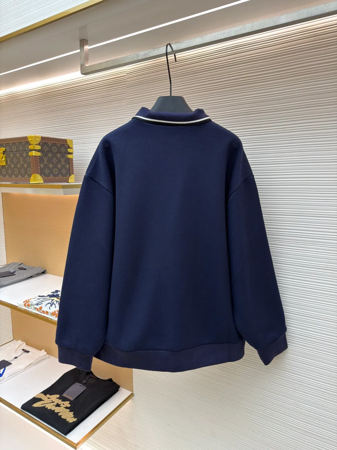 MIUMIU letter embroidered pique lapel jacket ●Original version: 25400 purchased and developed ●Item number: 1681338-B20 ●Material: combed cotton fabric ●Technology: embroidery production ●Color: navy ●Version: Fitted version ●Weight: about 1130 grams ●Size: 36-38-40-42 ●Description: This jacket is made of high-count combed cotton blended fabric, which is crisp and soft to the touch. The neckline is a classic lapel design, and the edges are decorated with double topstitching in contrasting colors. The black and white lines are precisely aligned, demonstrating the brand's control of details. The placket is equipped with a custom metal zipper. Its smoothness has been tested many times for wear resistance, and there is no lag when closing. The "miu miu" logo on the chest adopts high-precision embroidery technology, with fine and even stitching and full three-dimensionality. There are three-dimensional pockets on both sides of the body, and the edges of the pockets are hemmed to prevent the fabric from coming off. The ribs on the cuffs and hem are made of high-elastic knitting technology to ensure fit and resilience when worn. The overall tailoring follows an oversize silhouette, and the splicing of the body uses double stitching + overlocking techniques to ensure fastness and prevent threads from being exposed. Every craft detail reflects the brand's high-end clothing making standards.