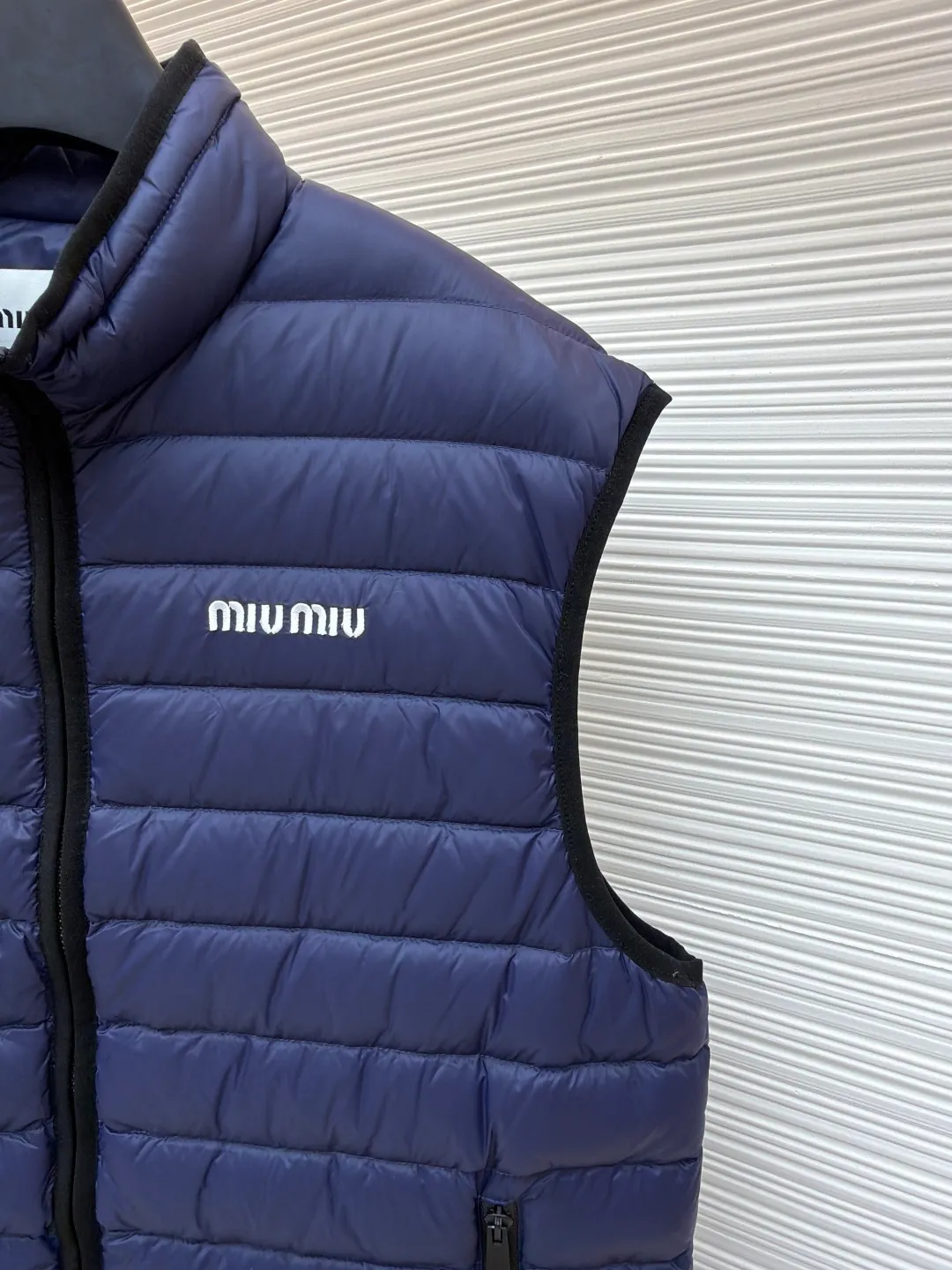 MIUMIU embroidered down vest ●Original version: purchased and developed by 15870 ●Item number: 1681121-B70 ●Fabric: high-quality down fabric ●Technology: embroidery production ●Version: fitted version ●Weight: about 380 grams ●Size: 34-36-38 ●Description: High-end nylon fabric made of high-count polyamide fiber, known for its excellent tensile strength and wear resistance. Its good flexibility makes the fabric less prone to wrinkles and keeps it crisp and stylish for a long time. The tight weave effectively blocks the invasion of cold wind and locks in the warm air generated by the down layer. The high-density nylon surface forms a certain lotus leaf effect, making it difficult for small water droplets to penetrate, keeping the interior dry and effectively extending the service life of the down. It uses 90 national standard high-quality down, with a filling capacity of 140 grams. It has high fluffiness, strong warmth retention, lightness and no burden, and can easily cope with cold weather. Whether it is urban commuting or outdoor leisure, this down jacket has become an indispensable luxury item in the winter wardrobe with its excellent performance and simple design. The logo adopts imported machine embroidery technology, uses advanced computer control systems and precision mechanical components to achieve mimiu embroidery operations, with high precision, smooth and delicate lines. The overall wiring is straight and delicate, the fabric is comfortable and soft, and the color is consistent without color difference. It can be matched with the same style to create a fashionable look and control various occasions. Customized accessories, complete with three standards, same style for men and women!