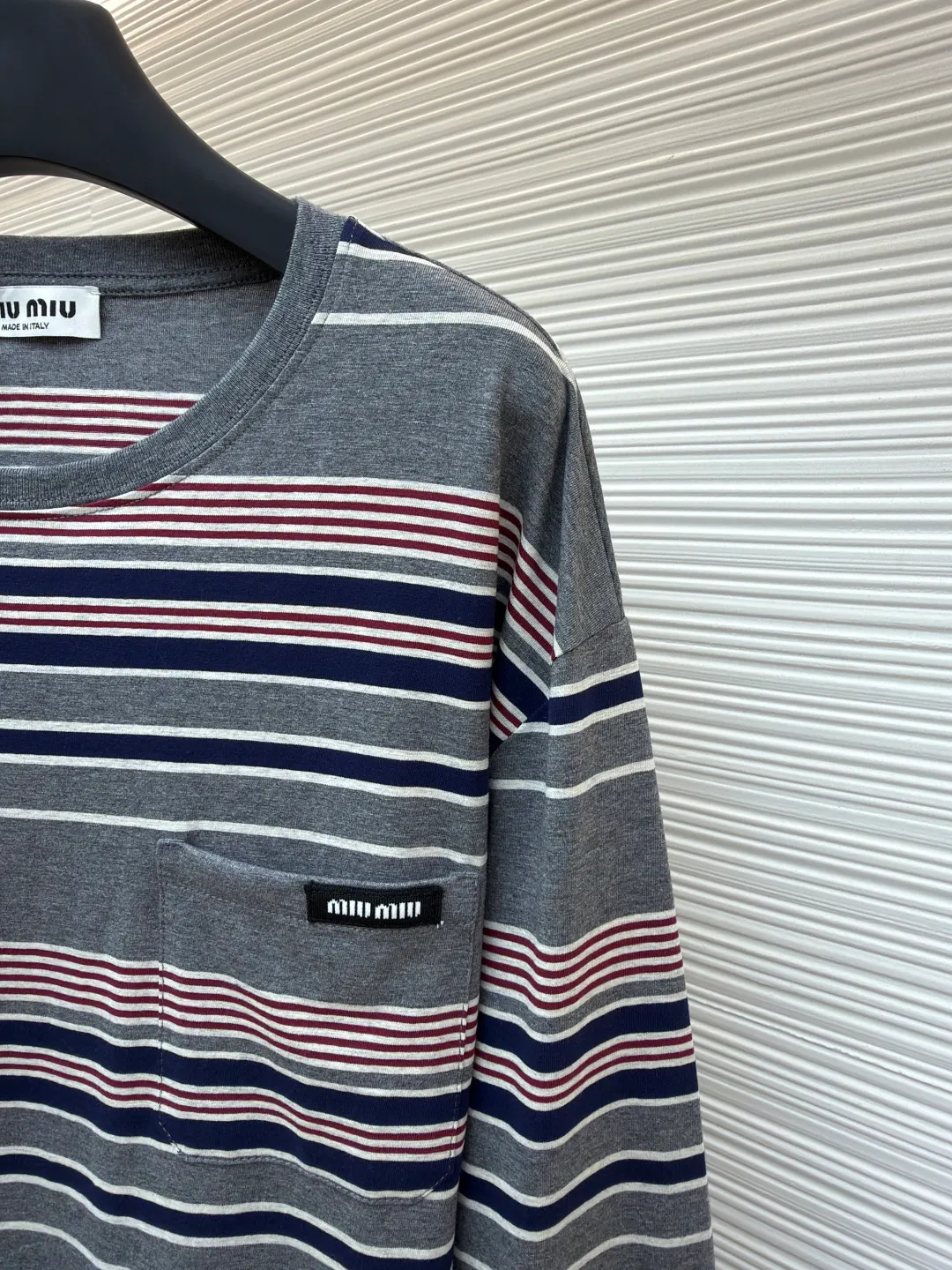 MIUMIU red, white and gray striped round neck long sleeves ●Original version: Purchased and developed for 6999 ●Item number: 1681640-A15 ●Fabric: Jacquard striped knitted fabric ●Technology: Woolen production ●Color: red, white and gray ●Version: Fitted version ●Weight: about 265 grams ●Size: S-M-L-XL ●Description: Using 24S jacquard stripe technology special textile compact cotton , 185g; with 32S double yarn frame, 380g. The fabric is made of 24-count combed cotton yarn and processed through a compact spinning process, which makes the yarn fibers tightly arranged and significantly reduces impurities and hairiness. The fabric structure is denser and smoother. It not only feels delicate and smooth, but its wear resistance and anti-pilling properties are also far superior to ordinary cotton fabrics. The weight of the fabric ensures that the fabric has good durability while maintaining the natural breathability and skin-friendly properties of cotton. It is very suitable for spring, summer and transitional seasons, and achieves the unity of comfort and quality. The striped effect is achieved through plain knitting technology where colored yarns are alternately woven. This is different from later printing. The color is firm and long-lasting, and the striped edges are clear and neat. The design that combines simple stripes with the possible jacquard texture of the underlying fabric increases the visual layering, avoids monotony, and embodies the design idea of ​​finding sophistication in simplicity. The overall wiring is straight and delicate, the fabric is comfortable and soft, and the color is consistent without color difference. It can be matched with the same style to create a fashionable look and control various occasions. Customized accessories, complete with three standards, same style for men and women!