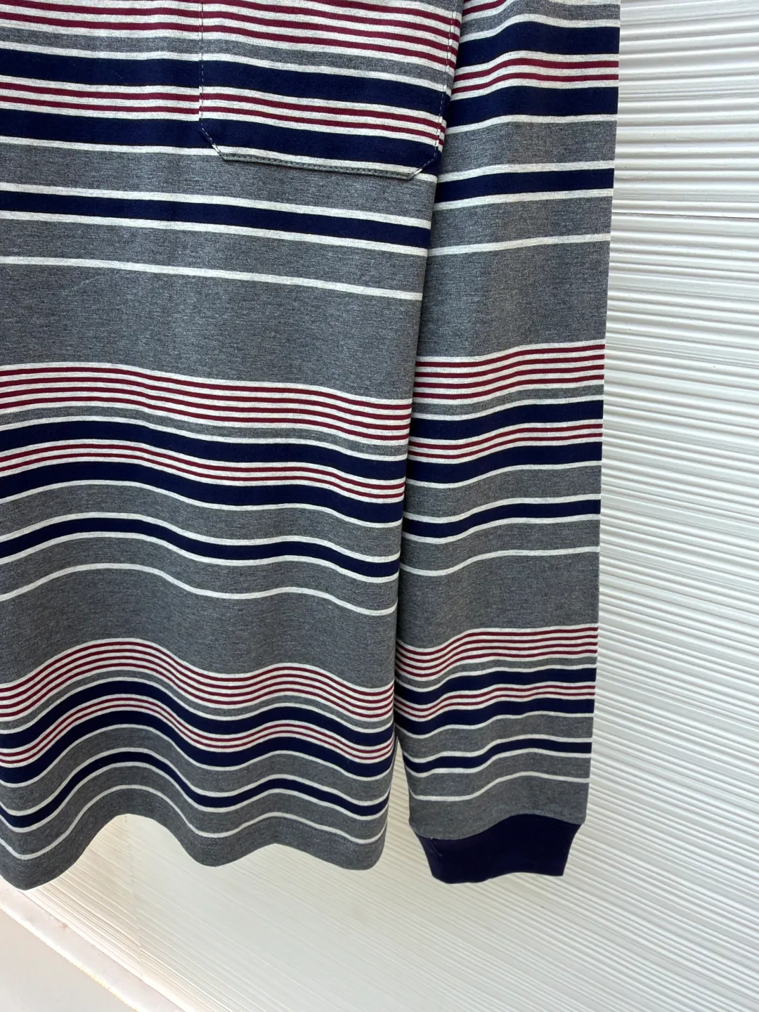 MIUMIU red, white and gray striped round neck long sleeves ●Original version: Purchased and developed for 6999 ●Item number: 1681640-A15 ●Fabric: Jacquard striped knitted fabric ●Technology: Woolen production ●Color: red, white and gray ●Version: Fitted version ●Weight: about 265 grams ●Size: S-M-L-XL ●Description: Using 24S jacquard stripe technology special textile compact cotton , 185g; with 32S double yarn frame, 380g. The fabric is made of 24-count combed cotton yarn and processed through a compact spinning process, which makes the yarn fibers tightly arranged and significantly reduces impurities and hairiness. The fabric structure is denser and smoother. It not only feels delicate and smooth, but its wear resistance and anti-pilling properties are also far superior to ordinary cotton fabrics. The weight of the fabric ensures that the fabric has good durability while maintaining the natural breathability and skin-friendly properties of cotton. It is very suitable for spring, summer and transitional seasons, and achieves the unity of comfort and quality. The striped effect is achieved through plain knitting technology where colored yarns are alternately woven. This is different from later printing. The color is firm and long-lasting, and the striped edges are clear and neat. The design that combines simple stripes with the possible jacquard texture of the underlying fabric increases the visual layering, avoids monotony, and embodies the design idea of ​​finding sophistication in simplicity. The overall wiring is straight and delicate, the fabric is comfortable and soft, and the color is consistent without color difference. It can be matched with the same style to create a fashionable look and control various occasions. Customized accessories, complete with three standards, same style for men and women!