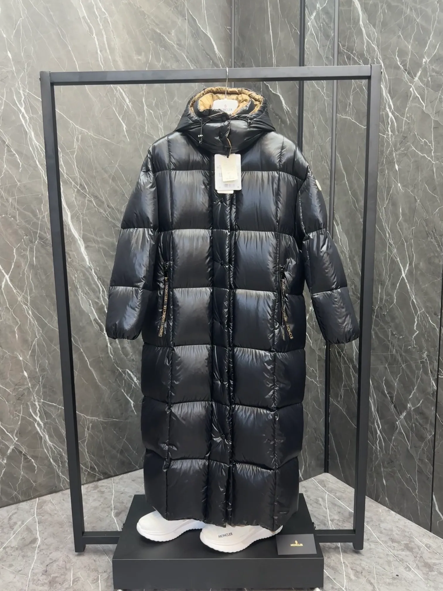 Special down  Parnaiba's long down jacket features graphic details and bold color blocking in signature patented nylon. The eye-catching design features large grille quilting and contrasting lining. The removable hood and adjustable hem make it easy to personalize the style, and the color-blocked pattern highlights the highly recognizable Moncler vibe. Details •Made from nylon laqué fabric •Contrast nylon laqué lining •Detachable hood with zipper and drawstring •Zip closure with black patented snap fastener ��Zip pocket Size: 0-4. Original runs large. D98108078950