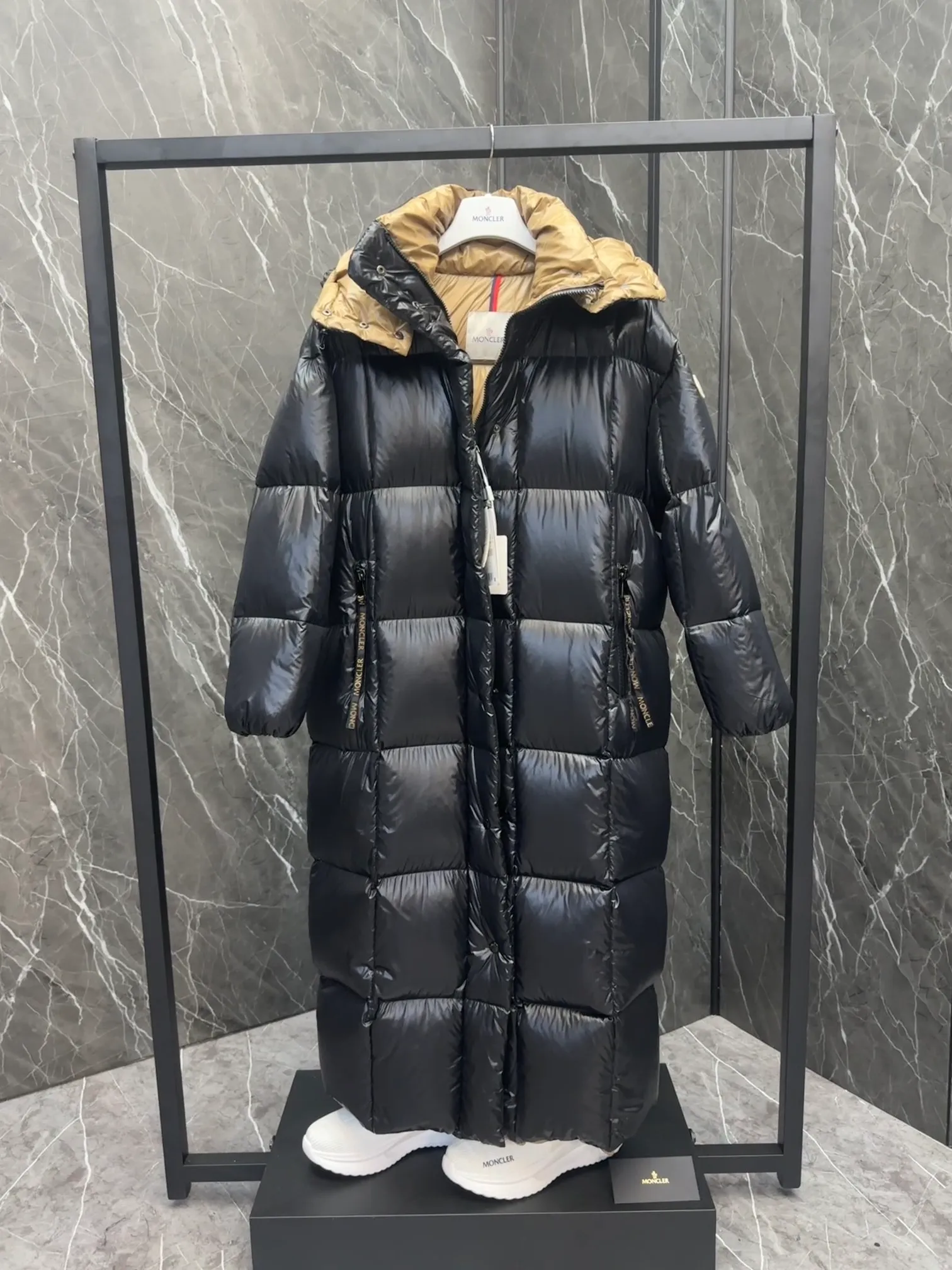 Special down  Parnaiba's long down jacket features graphic details and bold color blocking in signature patented nylon. The eye-catching design features large grille quilting and contrasting lining. The removable hood and adjustable hem make it easy to personalize the style, and the color-blocked pattern highlights the highly recognizable Moncler vibe. Details •Made from nylon laqué fabric •Contrast nylon laqué lining •Detachable hood with zipper and drawstring •Zip closure with black patented snap fastener ��Zip pocket Size: 0-4. Original runs large. D98108078950
