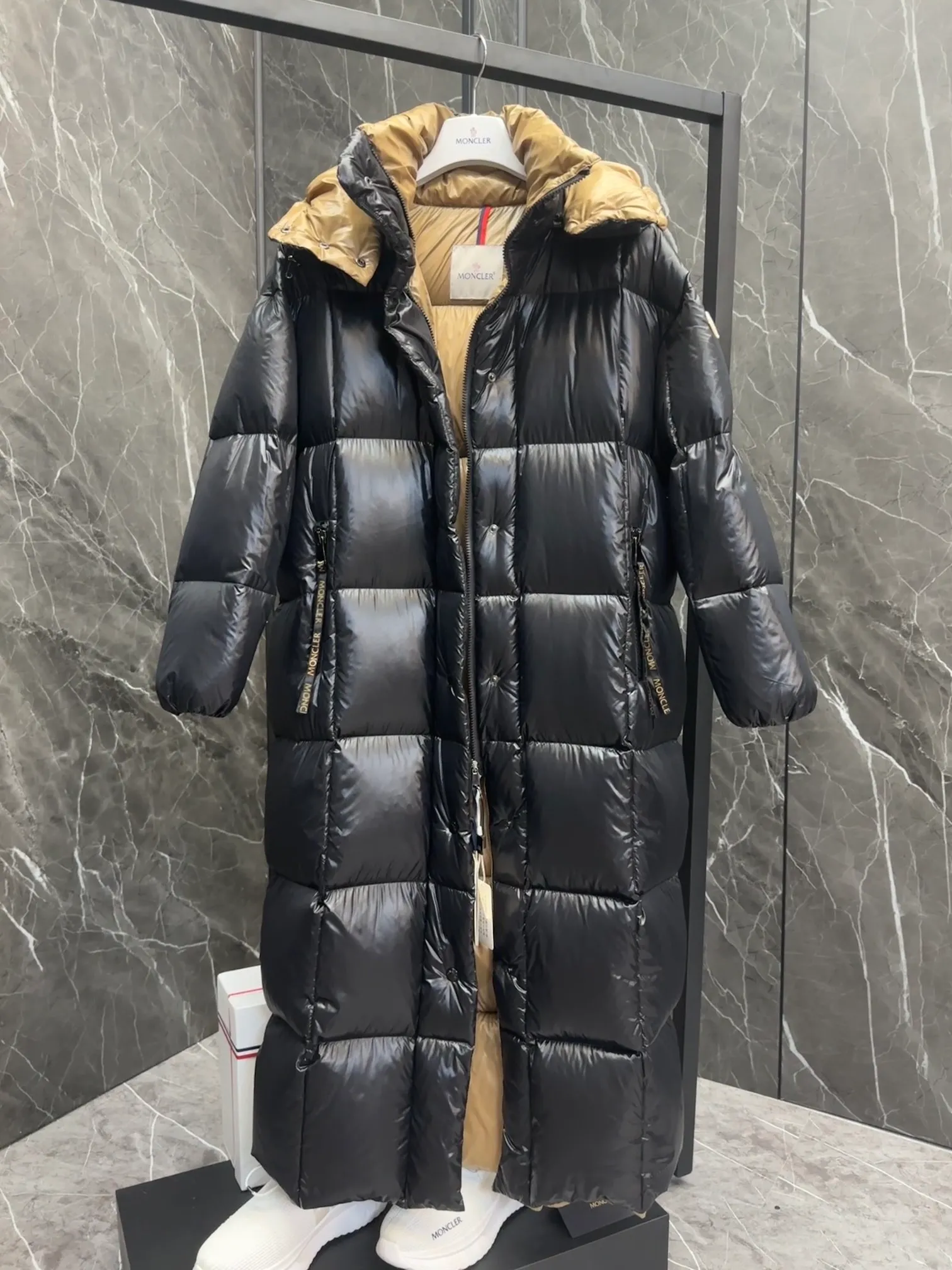 Special down  Parnaiba's long down jacket features graphic details and bold color blocking in signature patented nylon. The eye-catching design features large grille quilting and contrasting lining. The removable hood and adjustable hem make it easy to personalize the style, and the color-blocked pattern highlights the highly recognizable Moncler vibe. Details •Made from nylon laqué fabric •Contrast nylon laqué lining •Detachable hood with zipper and drawstring •Zip closure with black patented snap fastener ��Zip pocket Size: 0-4. Original runs large. D98108078950