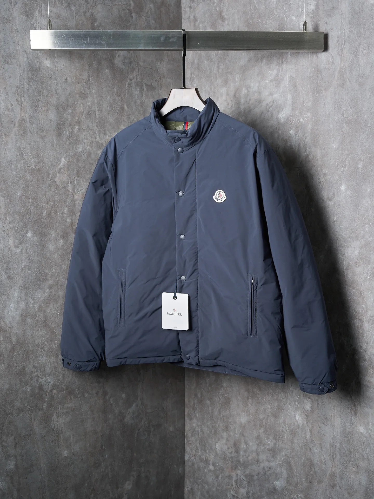 P900 Actual hanging auction] MONCLER/Maskled single-breasted zipper solid color badge stand collar down jacket [Ready stock] 1 2 3 4 High-quality filling: 90 white duck down is selected, weighing 210g, ensuring excellent thermal insulation performance. After strict screening and processing, the velvet is not easy to drill, ensuring durability. After selecting 100% polyester fiber and undergoing microfiberization treatment, the individual fibers become extremely fine, which greatly increases the fiber surface area, making the fabric soft, smooth, and close to natural fibers in touch. The high-density textile method makes the structure tight, thus giving it a certain degree of wrinkle resistance, windproof warmth and wear resistance.  The inner lining is made of 100% polyamide. The high-density and tight weaving process prevents fine lint from getting out of the gaps in the fabric. The smooth surface improves the putting on and taking off experience, and the excellent wear and tear resistance ensures damage caused by frequent use, while the light and soft texture does not affect the overall weight.  : The interior is quilted with imported No. 7 needles + anti-velvet thin threads, with 13 stitches every three centimeters. The stitches are straight and there is no skipped stitches.  The stand-up collar makes the overall lines look more concise and capable, can wrap the neck well, prevent cold wind from entering, and has excellent thermal insulation performance. Whether worn with a scarf or worn alone, combined with the characteristics of the version, it looks energetic, neat and not bloated.