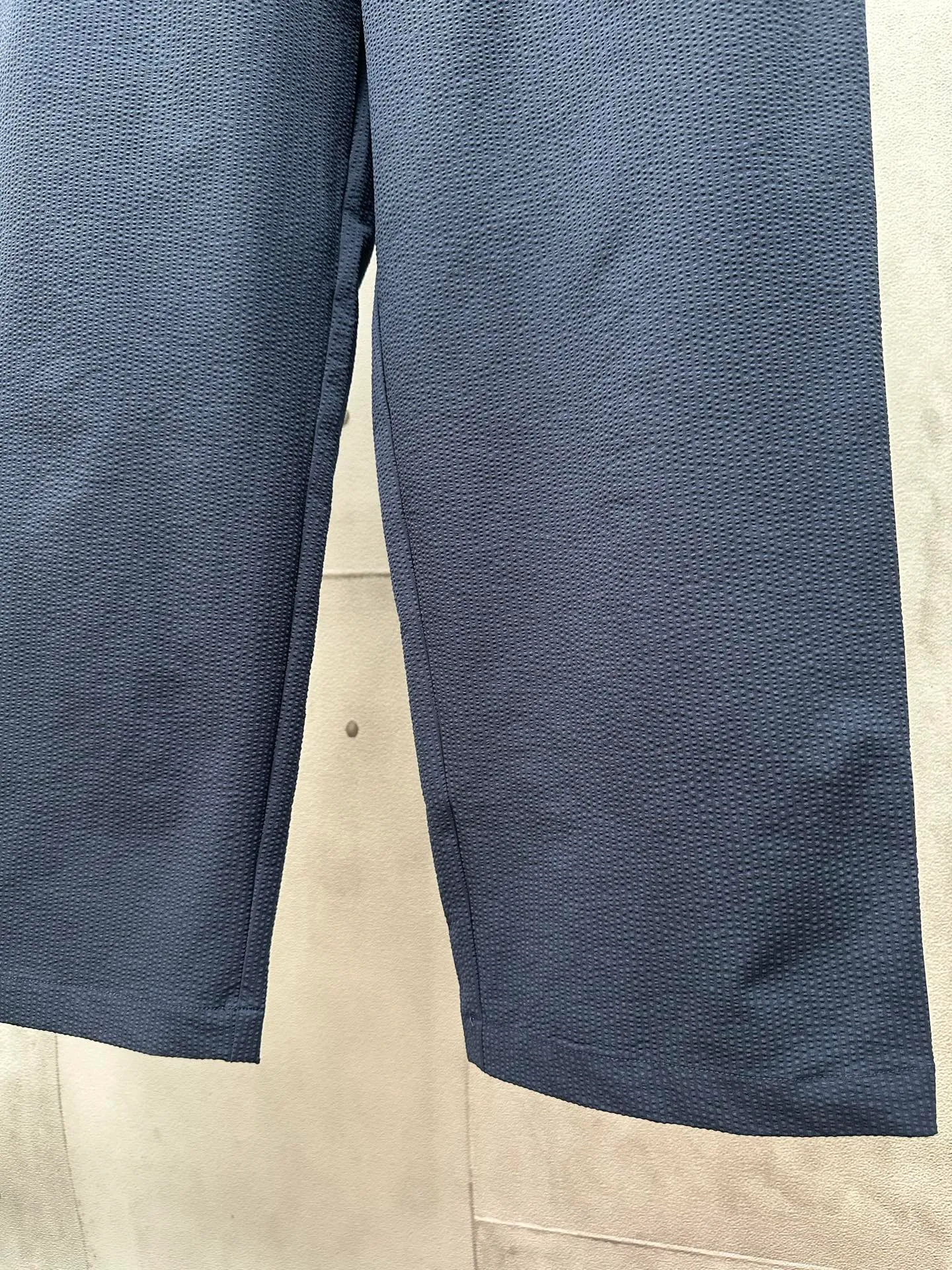 P400 MONCLER puff wrinkled trousers Fabric selection: Made of cotton blended woven fabric with 76% high cotton content + 24% polyester fiber. The high cotton content ensures that the fabric is soft, skin-friendly, and has good breathability. The addition of a small amount of polyester fiber balances the wrinkle resistance and elasticity of the overall fabric and greatly reduces its shrinkage. After preshrinking, dimensional changes during washing are negligible. The fusion of the two makes the fabric combine anti-wrinkle, quick-drying, easy care and other characteristics without losing the advantages of good wearing experience and strong breathability.  Bubble wrinkle technology: ground warp + bubble warp independent let-off. The bubble warp yarn feeding speed is about 20% higher than the ground warp yarn feeding speed. During weaving, the bubble warp is relaxed and accumulated, forming a naturally arched bubble unit. Through the alternating arrangement of yarns + floating length tissue changes, a clear grid frame is built between the bubble units, and finally the bubble three-dimensional effect and grid outline are locked through high-temperature heat setting.  Accessories: One-to-one customized drawstring head One-to-one customized LOGO labeling SIZE: 1 2 3 4