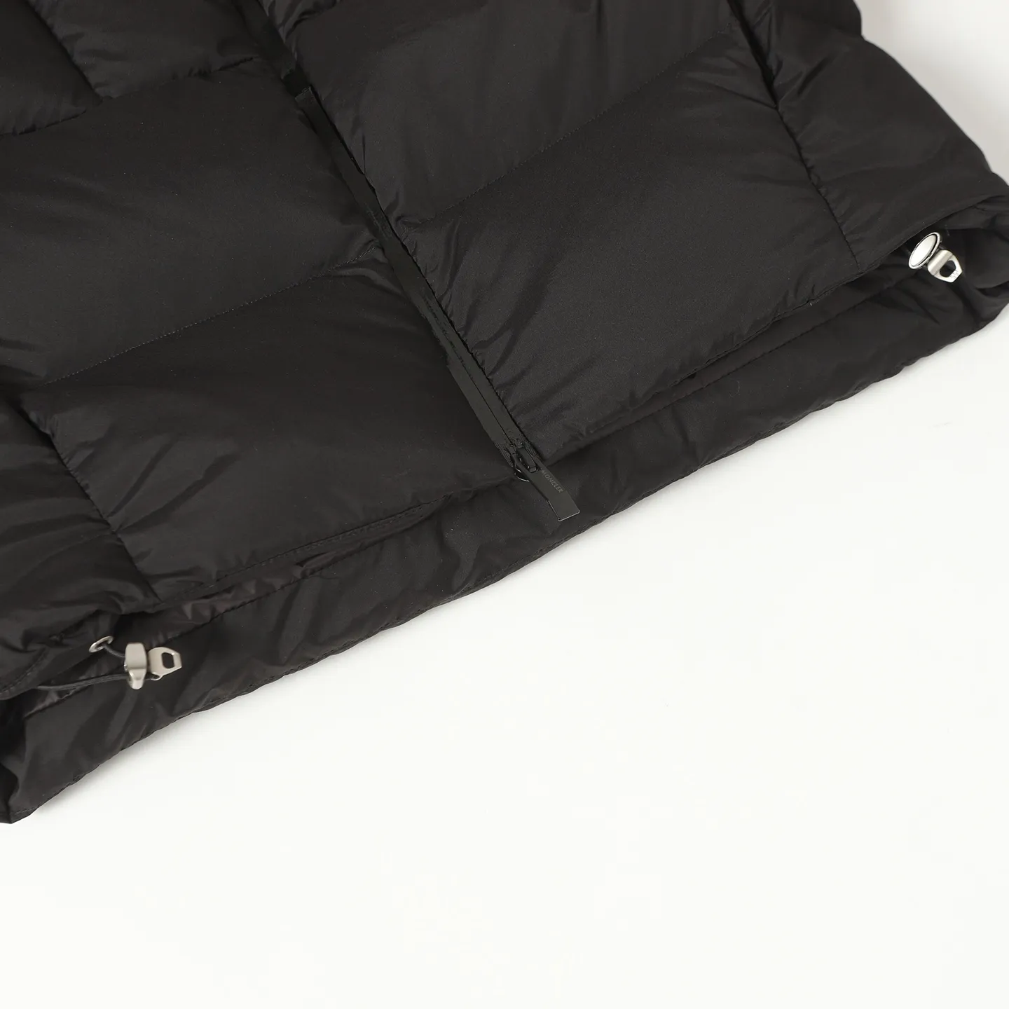 The design of the P860 Moncler Fusain short down jacket is inspired by the thrilling racing sports, echoing the three-dimensional tailoring and dynamic structure of the racing driver's uniform. Diamond quilting is used to build a thermal barrier, and the lightweight fabric is full of fluffy warmth. The silhouette is neat and not bulky, and the hooded design adds casualness. It is made of quilted nylon fabric, which has excellent warmth and protection. It is not only a textured armor to resist the cold wind when commuting, but also a fashion tool to create a minimalist and high-end feel when going out. In the cold winter, you can achieve the dual elegance of temperature and style with a piece of down. The short design features reflective zippers for a modern look. Code number: 12345 Color: black, gray