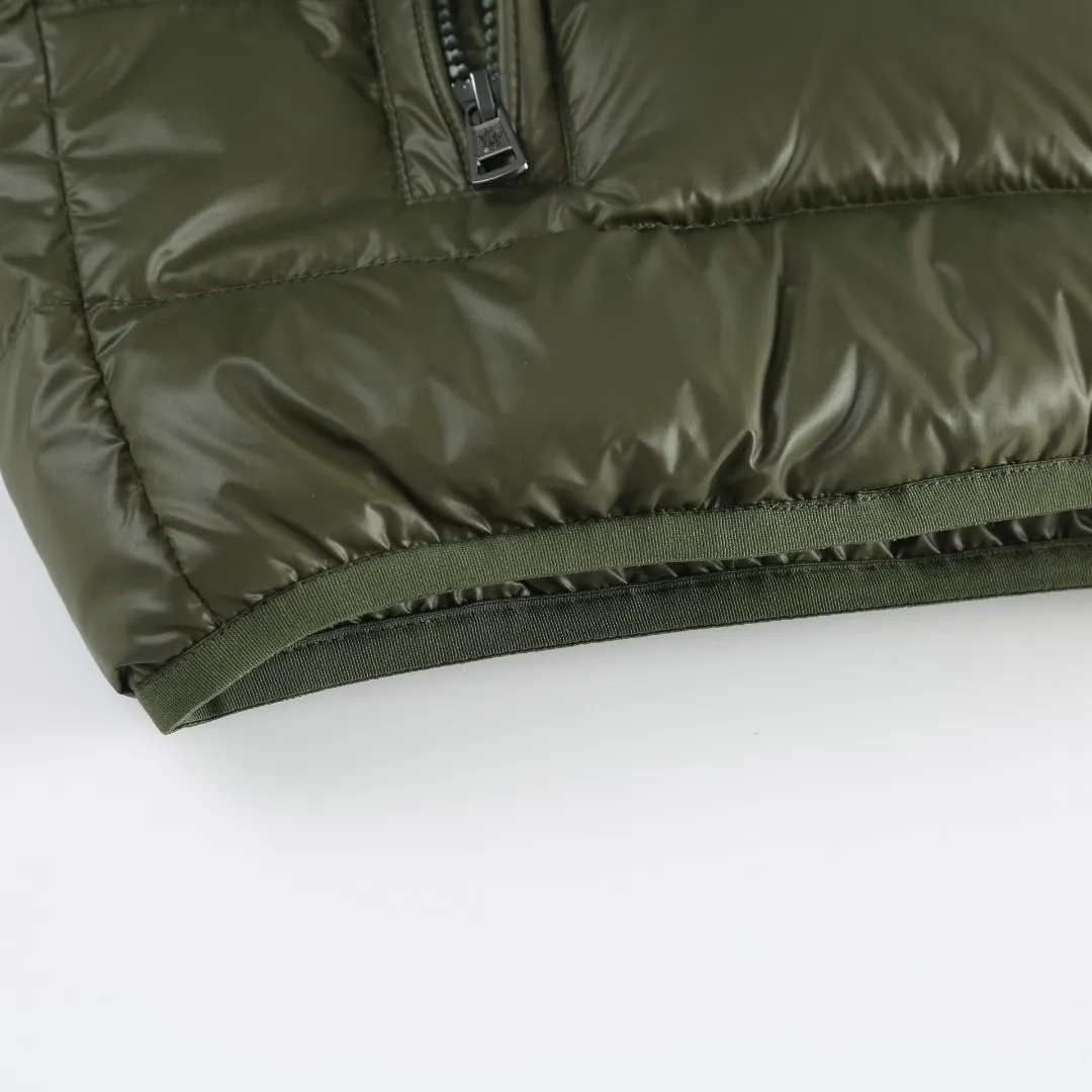 P900 MONCLER hooded brim quilted embroidered down jacket Fabric selection: The longue saison fabric is made of high-count polyamide fiber, which is known for its excellent tensile strength and lightness. Its good flexibility makes the fabric less prone to wrinkles and keeps it crisp and stylish for a long time. The tight weave effectively blocks the invasion of cold wind and locks in the warm air generated by the down layer. The high-density nylon surface forms a certain lotus leaf effect, making it difficult for small water droplets to penetrate, keeping the interior dry and effectively extending the service life of the down.  Lining selection: High-density lining fabric made of ultra-fine denier, 0.08mm thickness to avoid increasing the overall weight and making it smooth to wear. The high-density woven structure forms a wind resistance layer to protect the thermal efficiency of the thermal layer from loss. It can also withstand the expansion pressure of down and prevent deformation and damage after long-term use.  Technology: The quilted letter logo on the brim uses contour quilting technology. The stitching is routed along the edge of the set outline, and the filler is compressed inside the letter graphic, so that the logo is three-dimensional and convex, and the pattern is clear.  High-quality filling: It is filled with 90% selected white duck down, weighing 210g, ensuring fluffy rebound, lightness and warmth.  Accessories: one-to-one customized zipper pendant, one-to-one customized badge, one-to-one customized three-label SIZE: 1 2 3 4