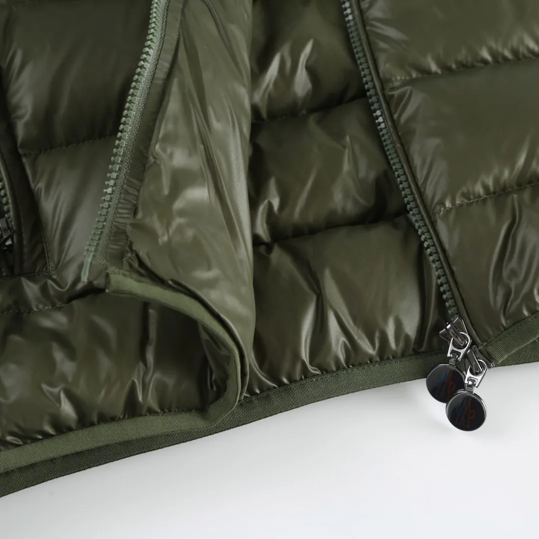 P900 MONCLER hooded brim quilted embroidered down jacket Fabric selection: The longue saison fabric is made of high-count polyamide fiber, which is known for its excellent tensile strength and lightness. Its good flexibility makes the fabric less prone to wrinkles and keeps it crisp and stylish for a long time. The tight weave effectively blocks the invasion of cold wind and locks in the warm air generated by the down layer. The high-density nylon surface forms a certain lotus leaf effect, making it difficult for small water droplets to penetrate, keeping the interior dry and effectively extending the service life of the down.  Lining selection: High-density lining fabric made of ultra-fine denier, 0.08mm thickness to avoid increasing the overall weight and making it smooth to wear. The high-density woven structure forms a wind resistance layer to protect the thermal efficiency of the thermal layer from loss. It can also withstand the expansion pressure of down and prevent deformation and damage after long-term use.  Technology: The quilted letter logo on the brim uses contour quilting technology. The stitching is routed along the edge of the set outline, and the filler is compressed inside the letter graphic, so that the logo is three-dimensional and convex, and the pattern is clear.  High-quality filling: It is filled with 90% selected white duck down, weighing 210g, ensuring fluffy rebound, lightness and warmth.  Accessories: one-to-one customized zipper pendant, one-to-one customized badge, one-to-one customized three-label SIZE: 1 2 3 4