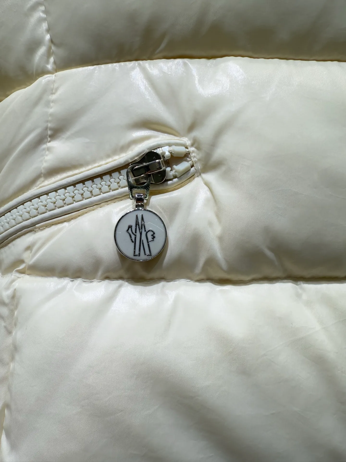 P1140 Moncler Barante series short waisted down jacket. The Barante down jacket is made of glossy nylon fabric and is inspired by the 1970s. The short version features a nipped-in waist and an A-line silhouette, highlighting a feminine style. An adjustable hood and signature logo patch add finishing touches.  Fabric: Made of nylon laque fabric, Nylon laque lining, filled with down (90 white goose down) Craftsmanship: Adjustable hood, zipper and snap closure, zipper pocket Adjustable cuffs (supports NFC function Color: black pink off-white Size: 0 1 2 3 4446080