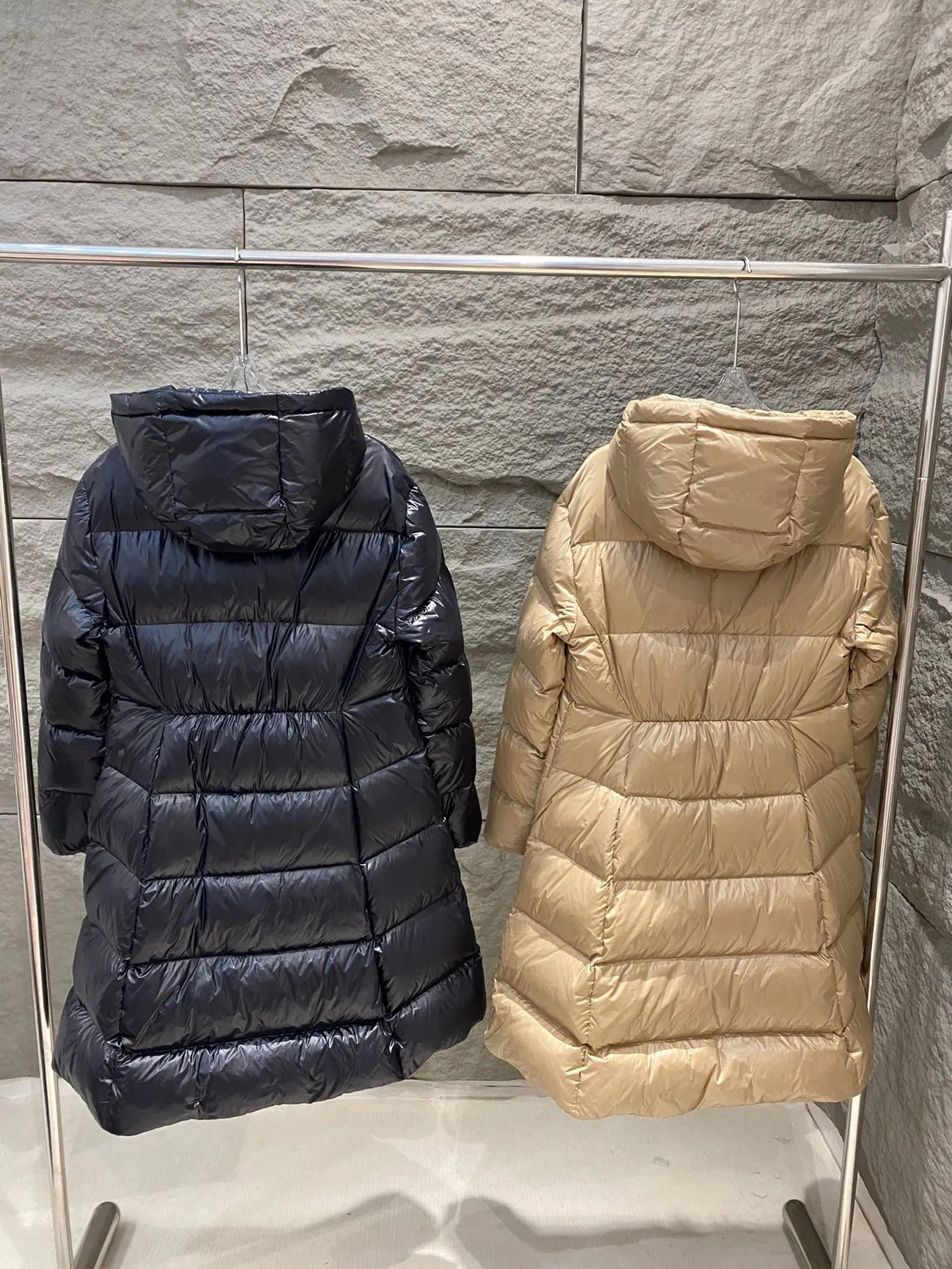 P1060 Moncler's new Bellevue women's long belted down jacket. The Bellevue down jacket is made of iconic nylon laqué fabric, interpreting classic Moncler style. Long design, the fabric has been functionally treated for a gorgeous lustrous effect. This hooded thermal piece has a feminine silhouette and an elastic waistband. From day to night, from the city to the mountains, it can be easily handled. Color: Black/Camel Beige Size: 0/1/2/3